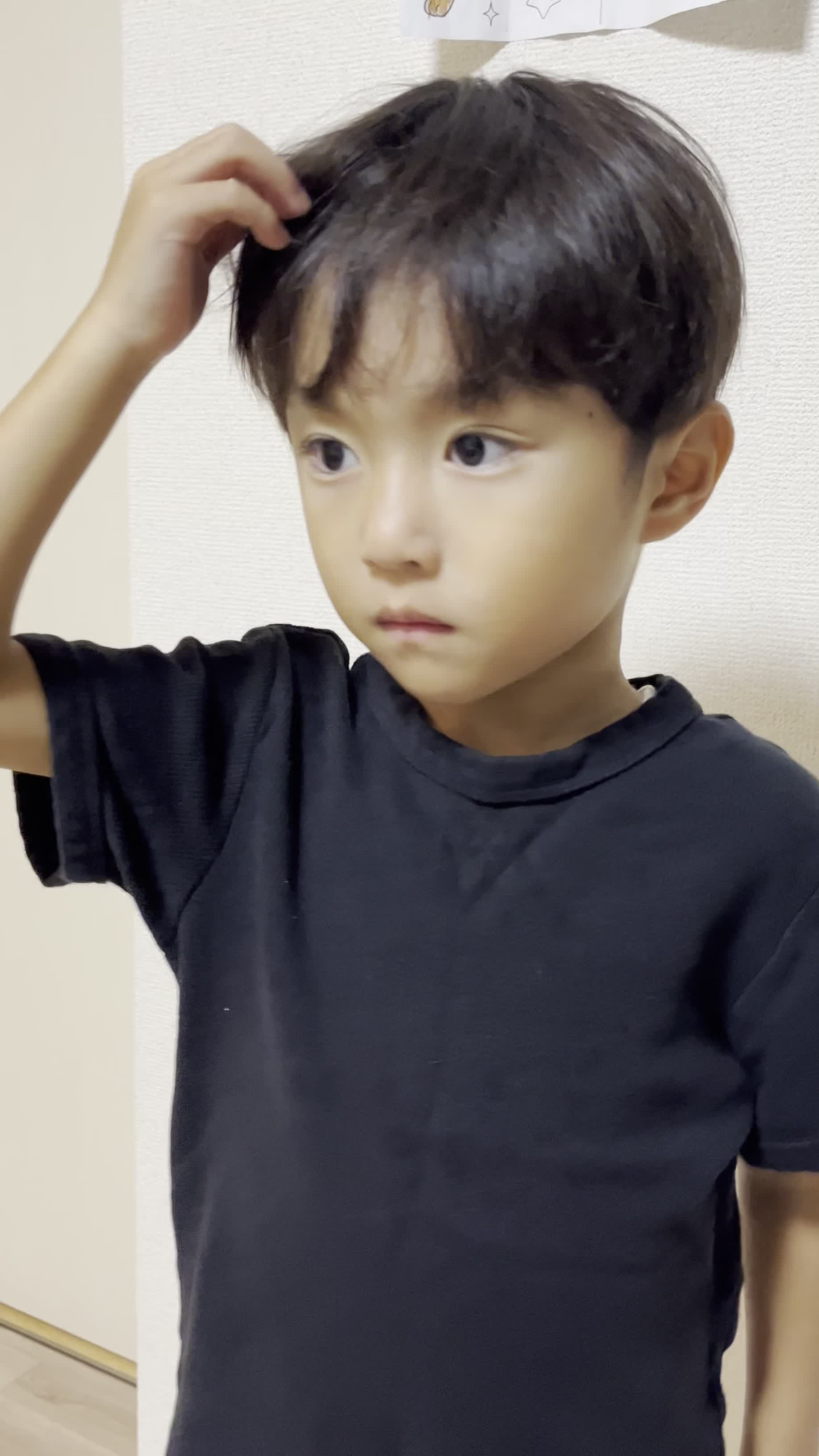 髪を気にしながらリビングで立ち止まり、少し困った表情を浮かべる