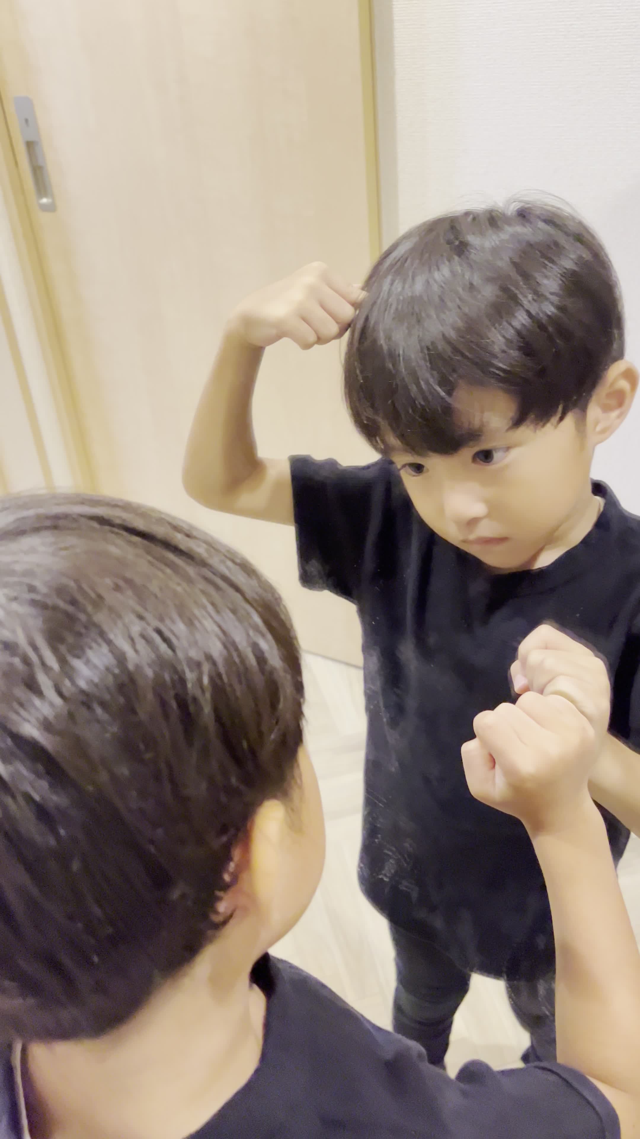 頭皮を指で押さえながら、真剣に自分を見つめている表情をする