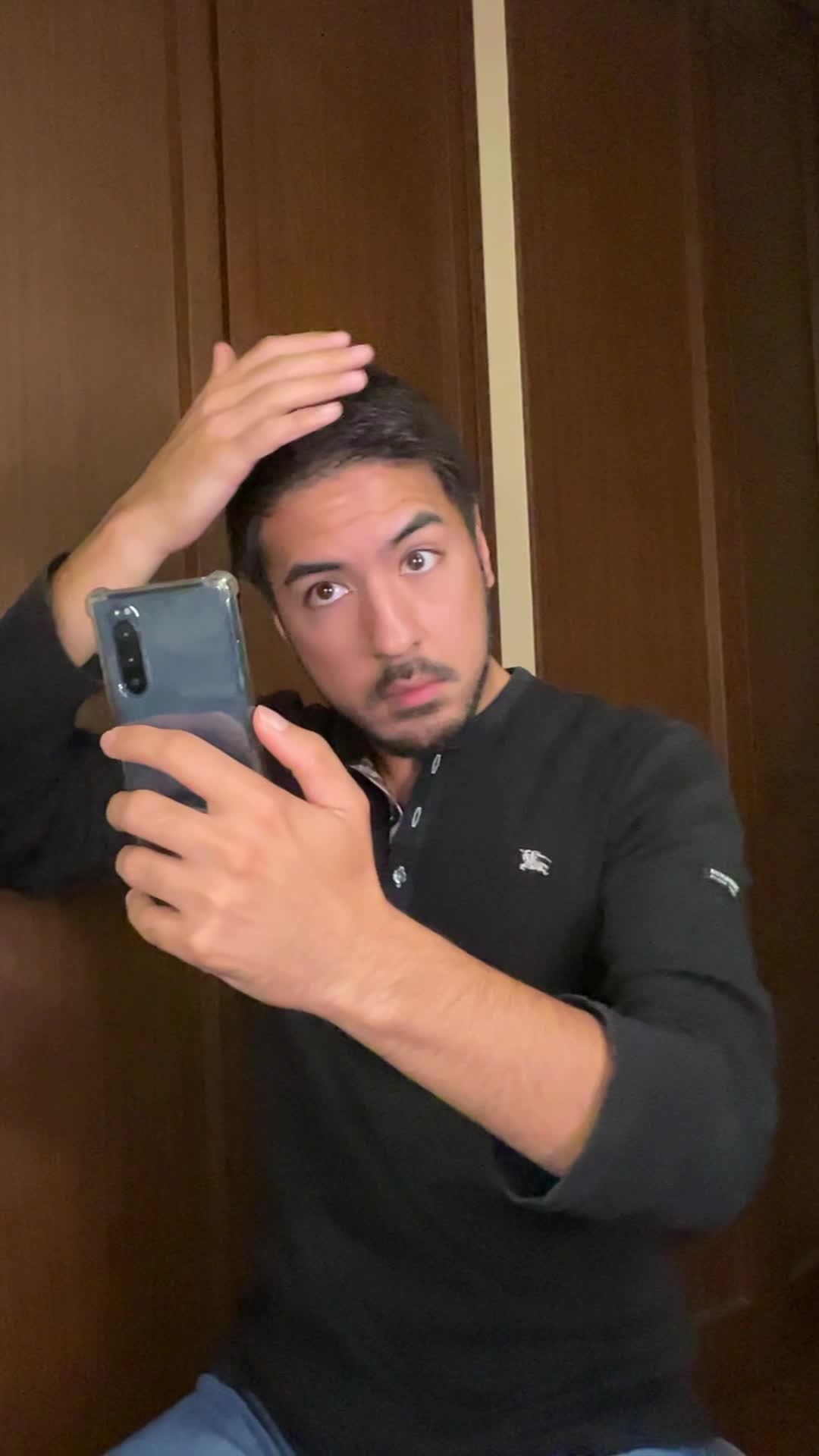 スマホの前で髪を軽くかき上げながら、自分の姿を確認する