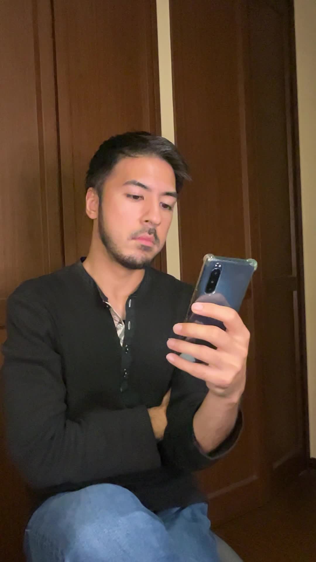 スマホでAGA治療に関する情報を調べている様子を演じる