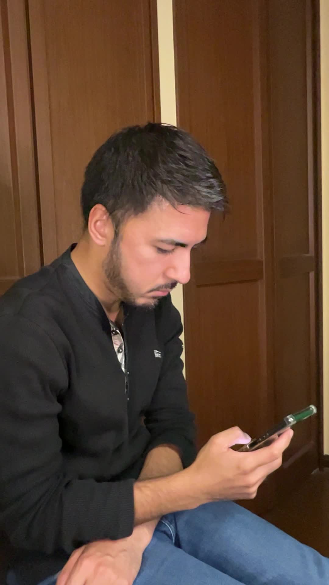 スマホを持ったまま、少し俯き加減で考え込む仕草をする