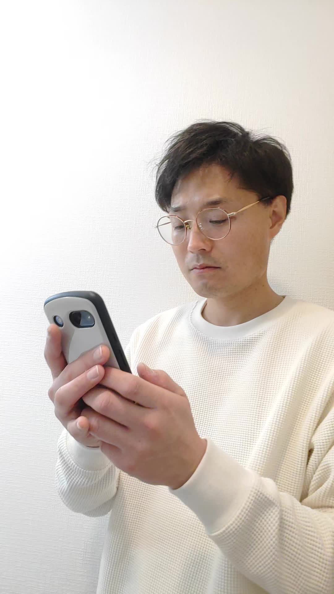 スマホの画面をスワイプしながら、じっくり悩む様子を演じる