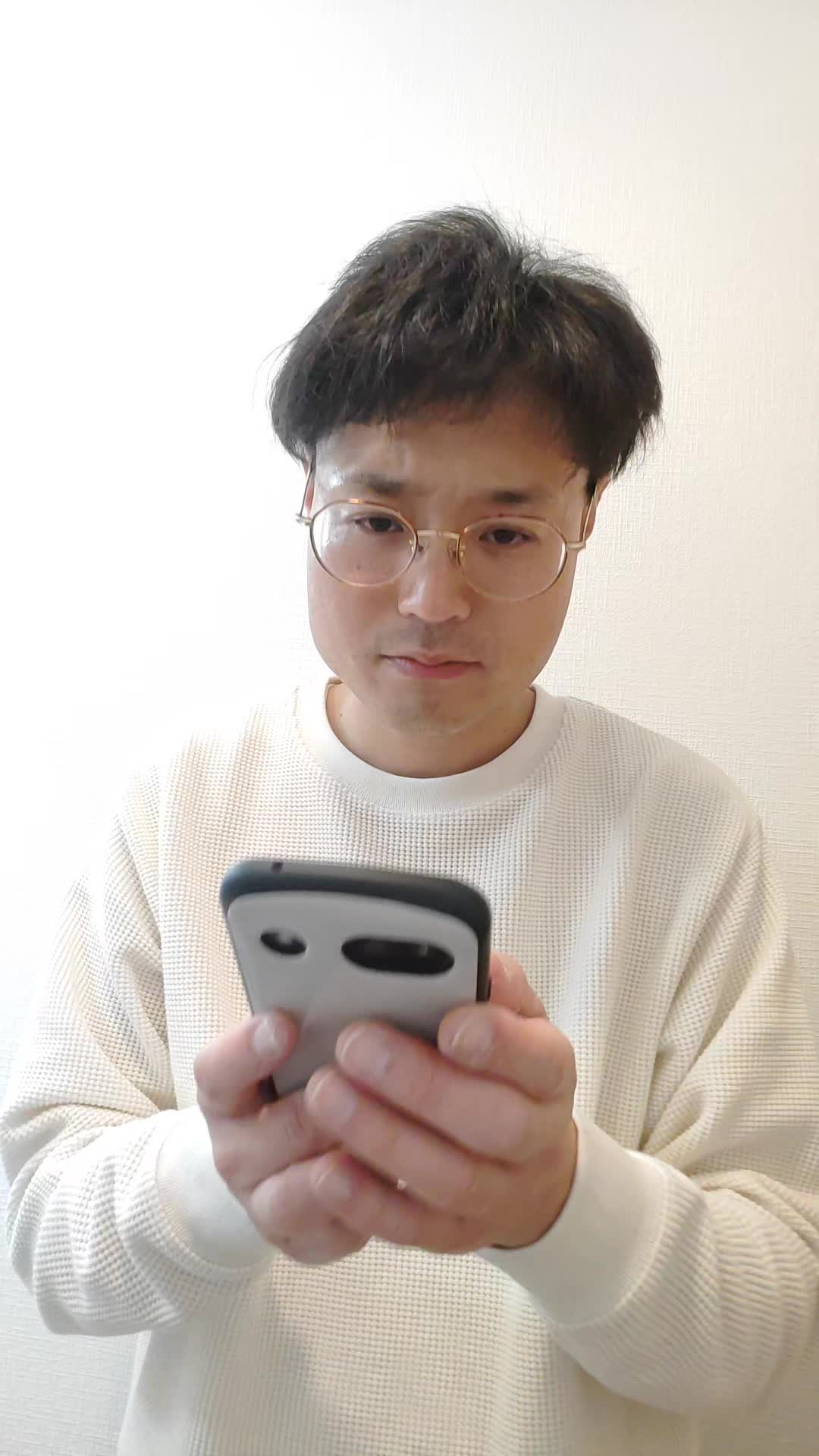 スマホを両手で持ち、AGAクリニックの評判をじっくり確認している様子