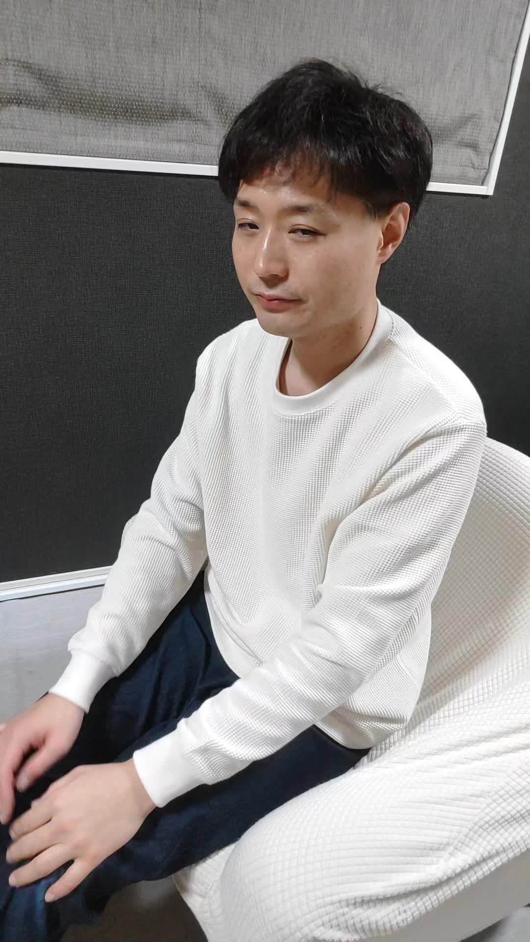 椅子に腰掛け、両手で顔を覆い、悩んでいる様子を表現する