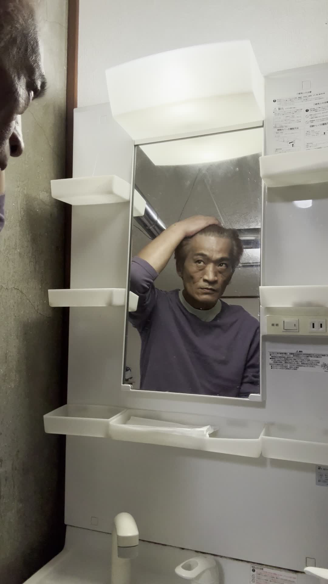 鏡の前で髪を軽くかき上げながら、自分の姿を確認する