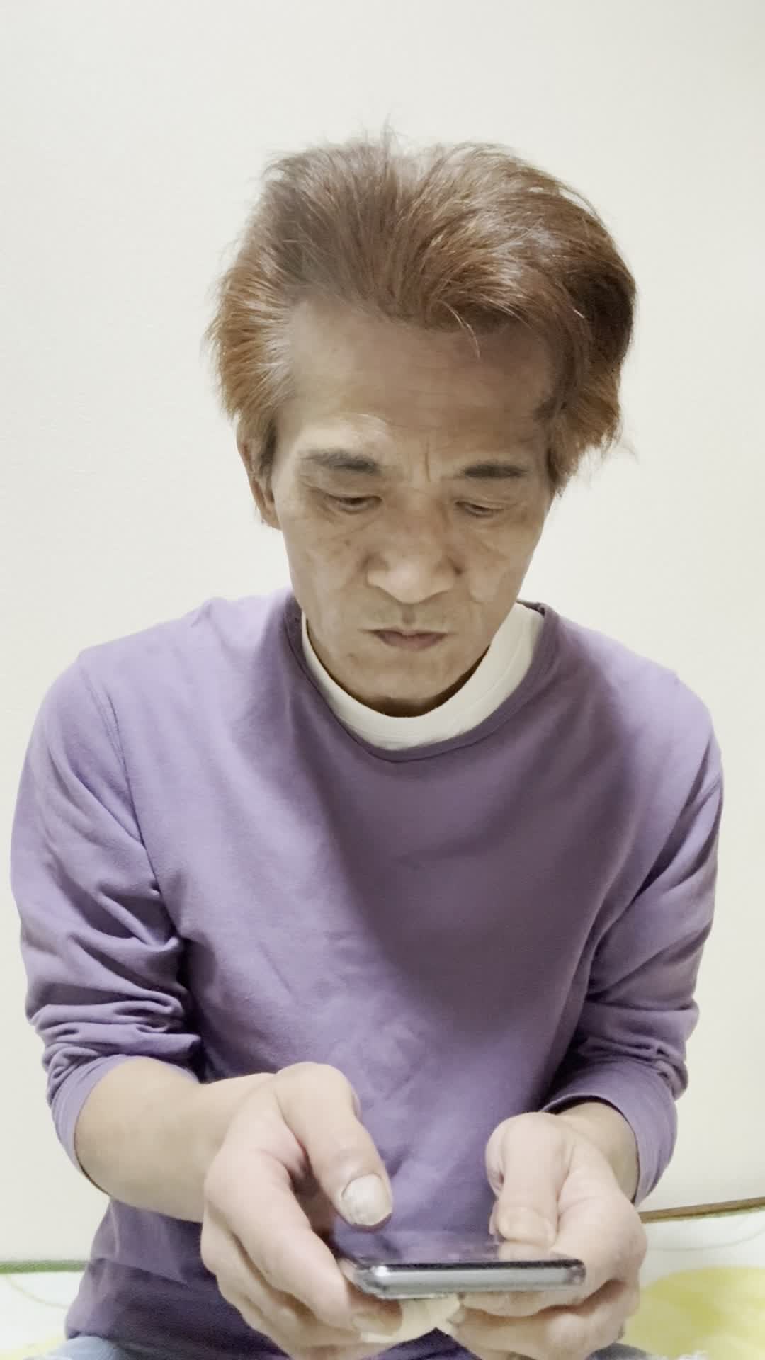 スマホを両手で持ち、AGAクリニックの評判をじっくり確認している様子