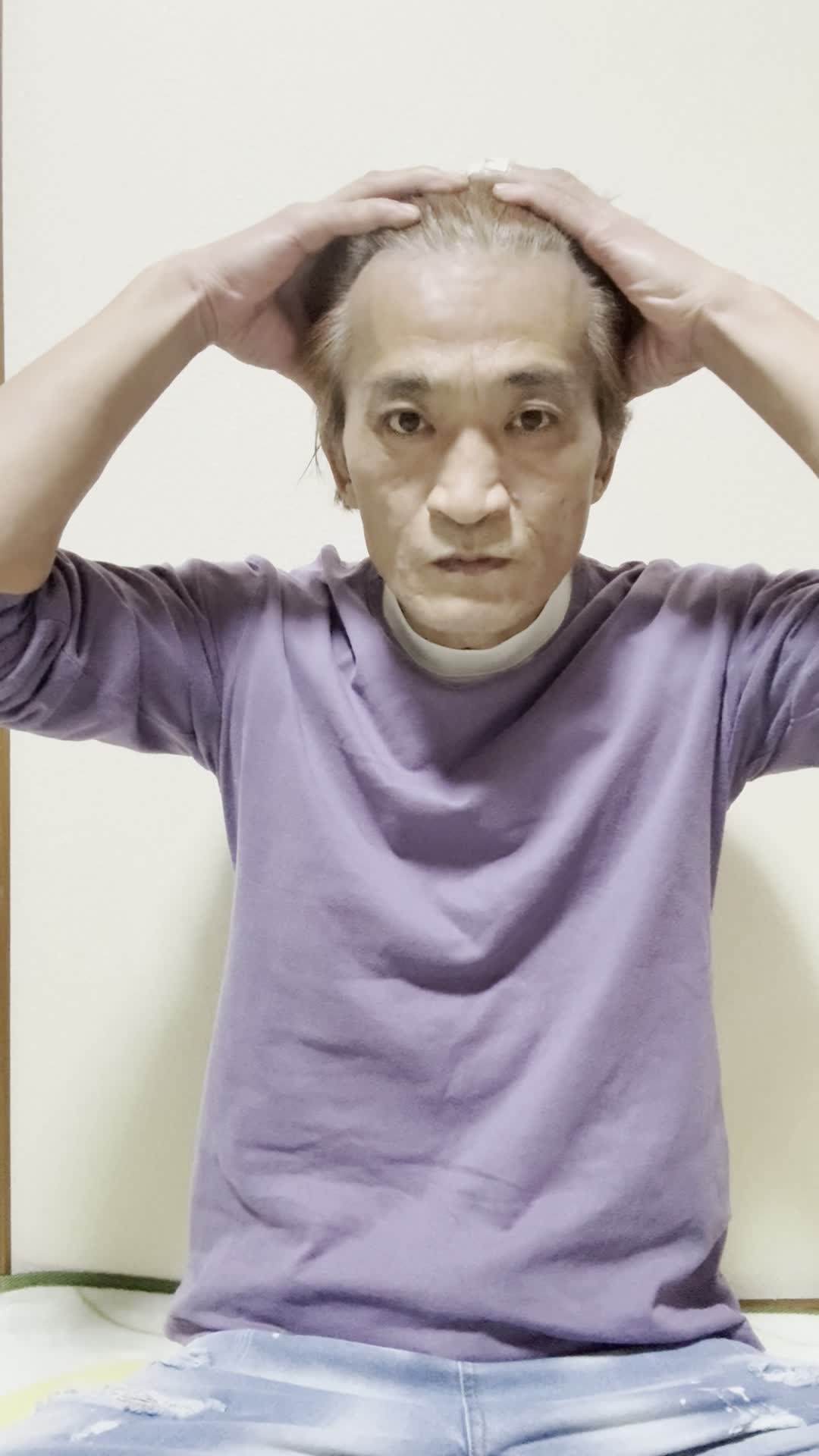 頭皮を指で押さえながら、真剣に自分を見つめている表情をする