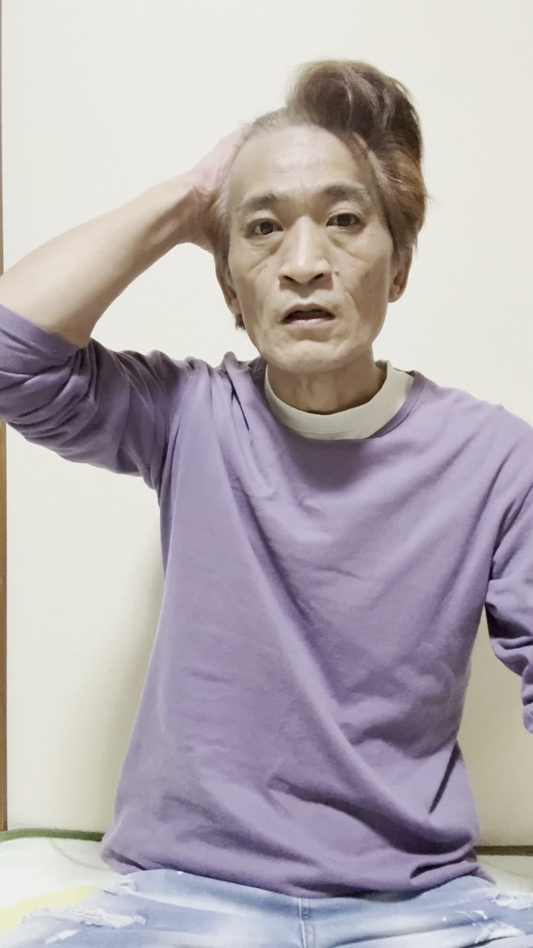 壁に寄りかかり、頭に手を当てて考え込む仕草をする