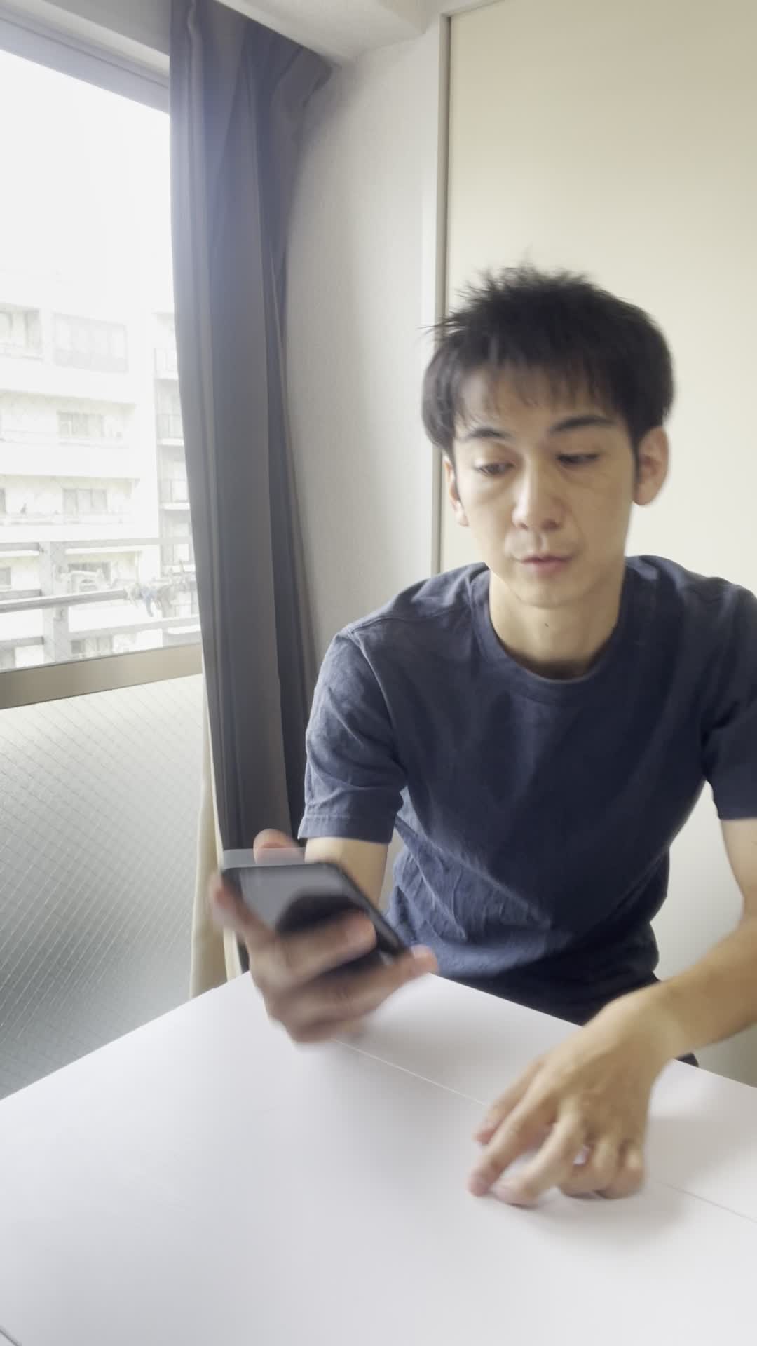 スマホを持ったまま、少し俯き加減で考え込む仕草をする