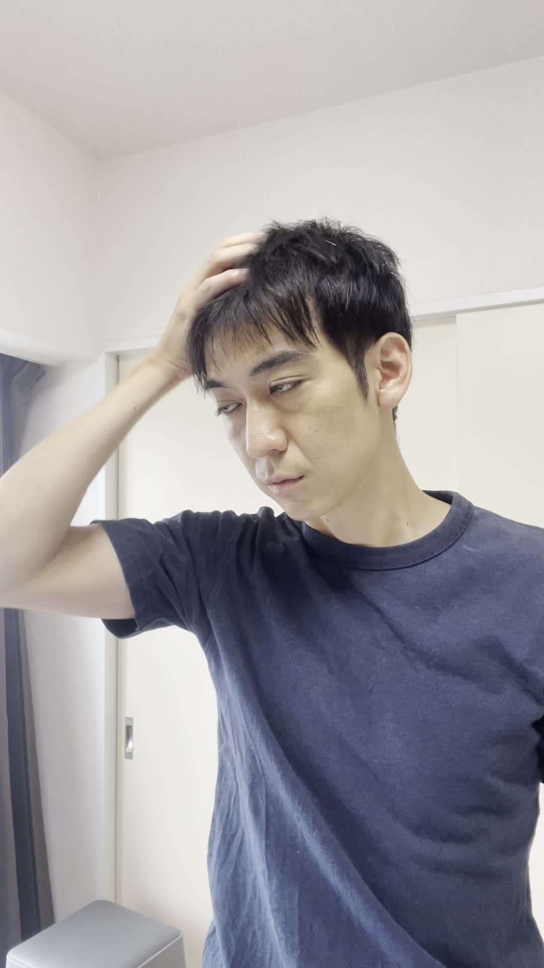 頭を軽く振りながら、髪の感触を確認している様子を演じる