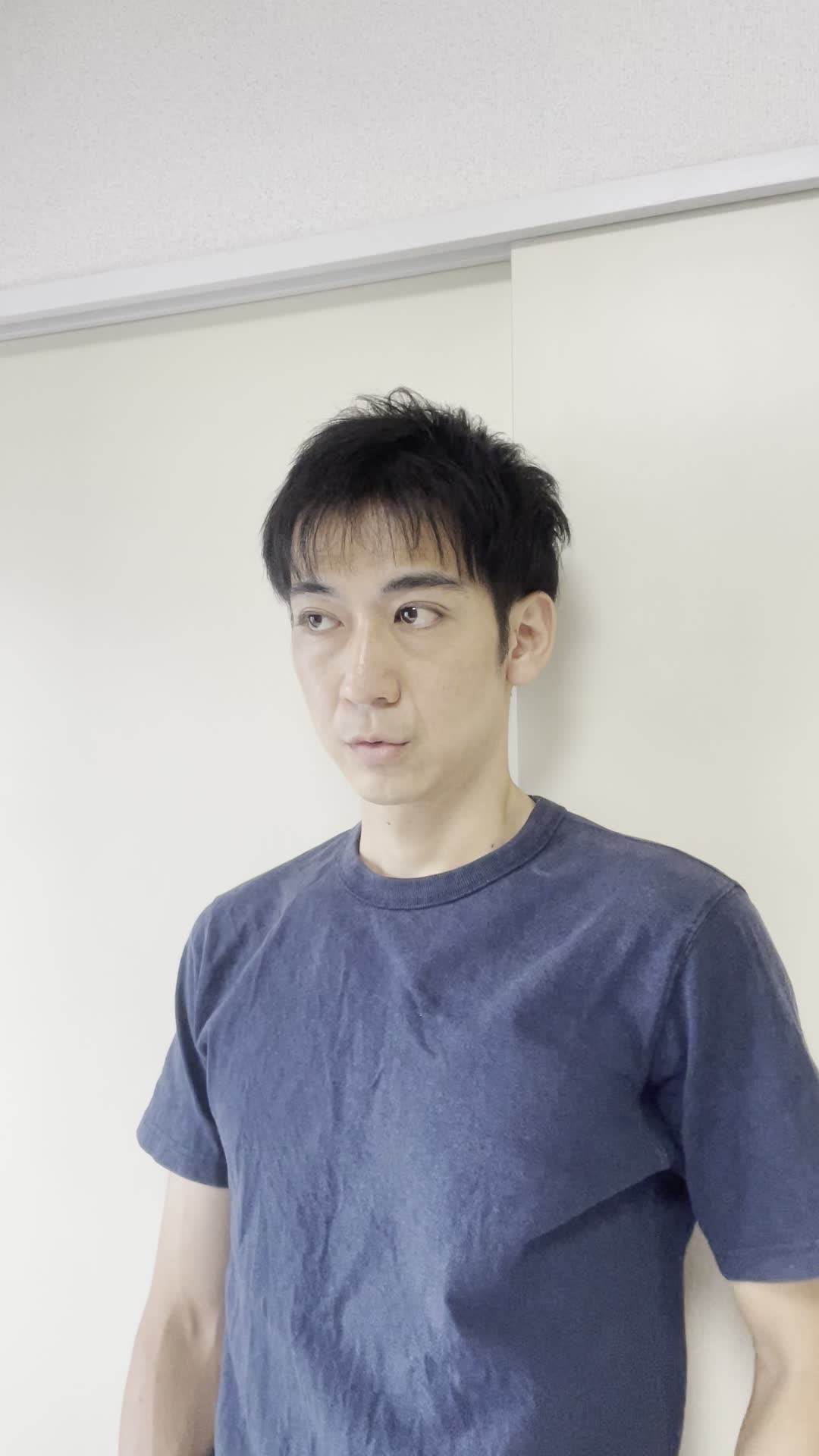 壁に背を預けて静かに目を閉じ、悩みを抱えている仕草をする