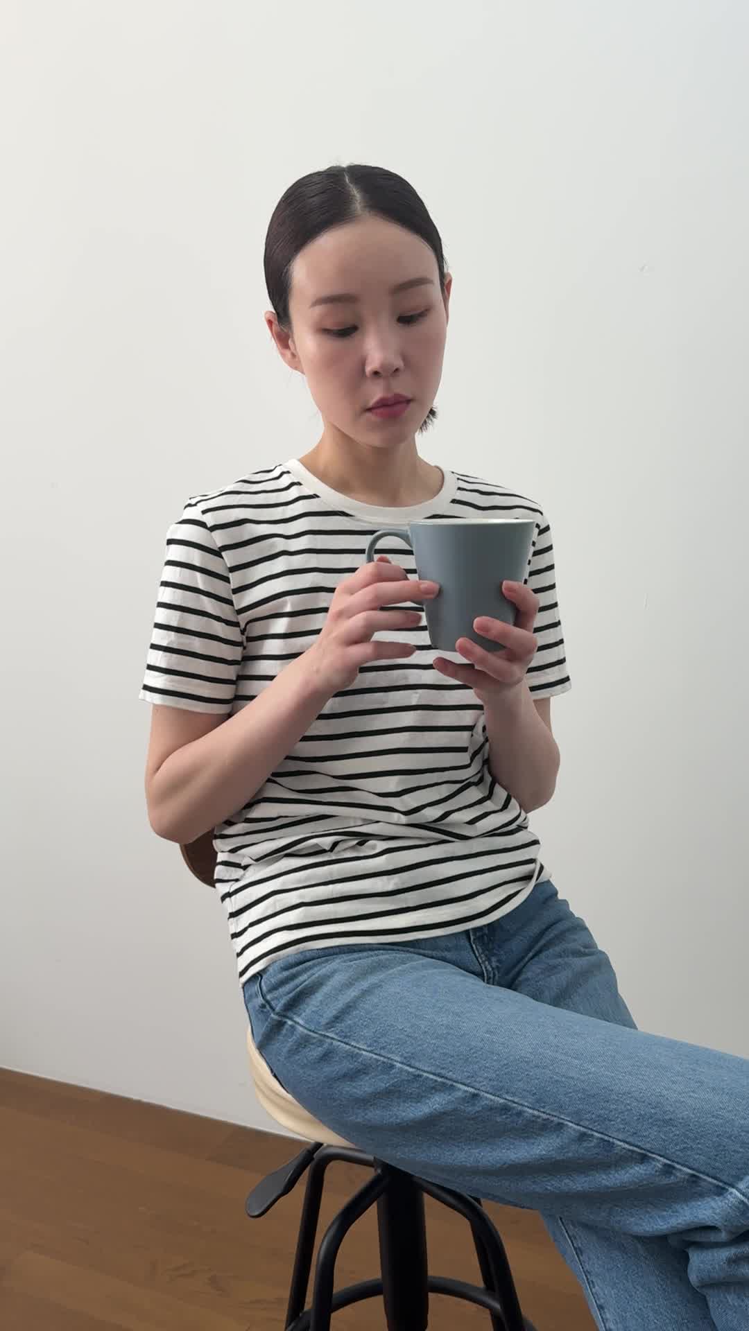 椅子に浅く腰掛け、「飲み物で少しでも元気を取り戻せる？」と悩む様子