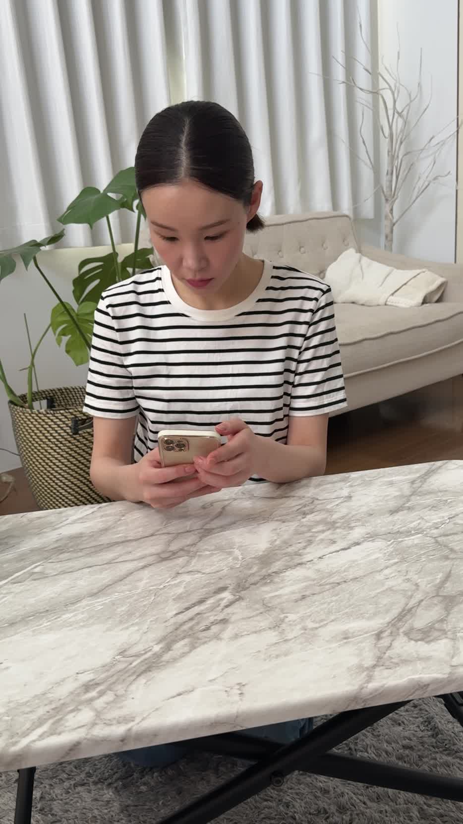 テーブルでスマホを見ながら、「体調を整える方法を必死に検索する」真剣な表情