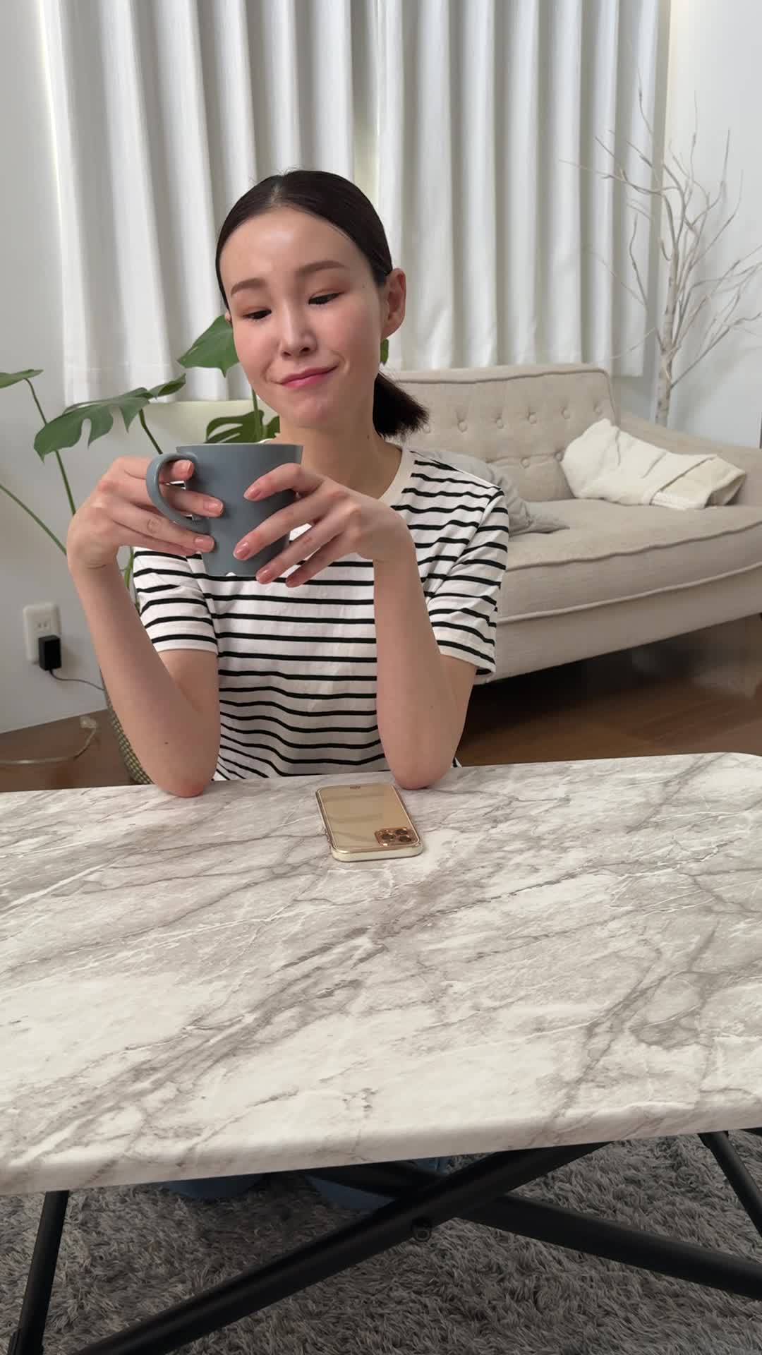 テーブルで飲み物を手に取り、「これで改善するなら試したい」と期待する微笑み