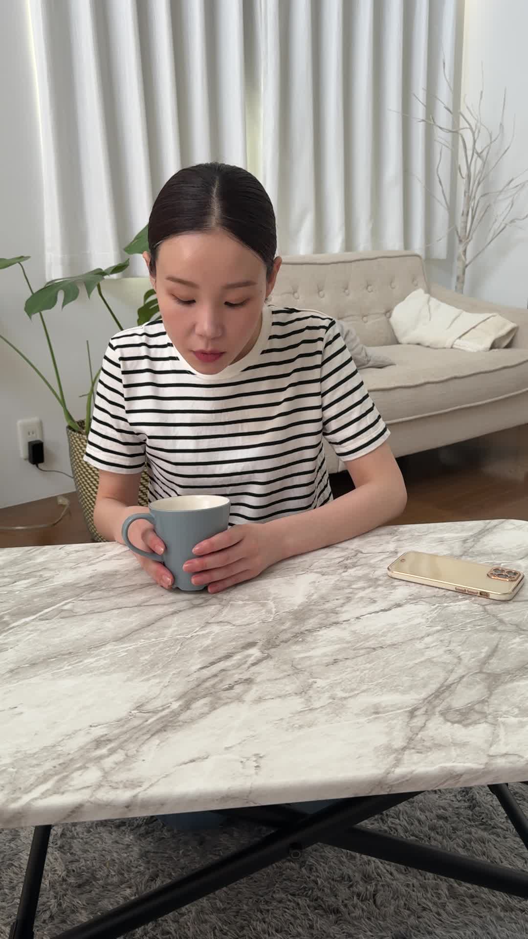 テーブルで飲み物を前に置き、「これが体に効けば嬉しい」と試す前の期待の様子