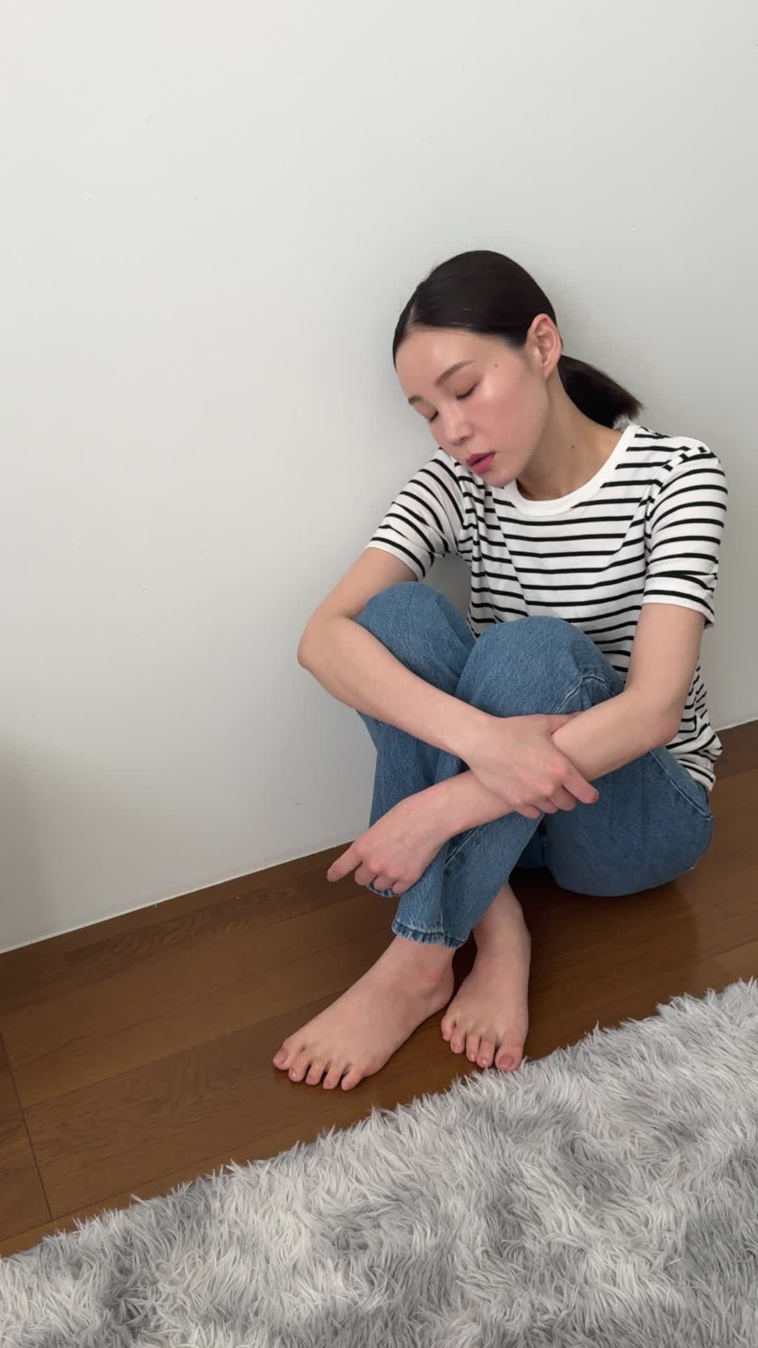 床に座り込み、「最近体が重くて動きが鈍い」と両手を膝に置いて考え込む姿