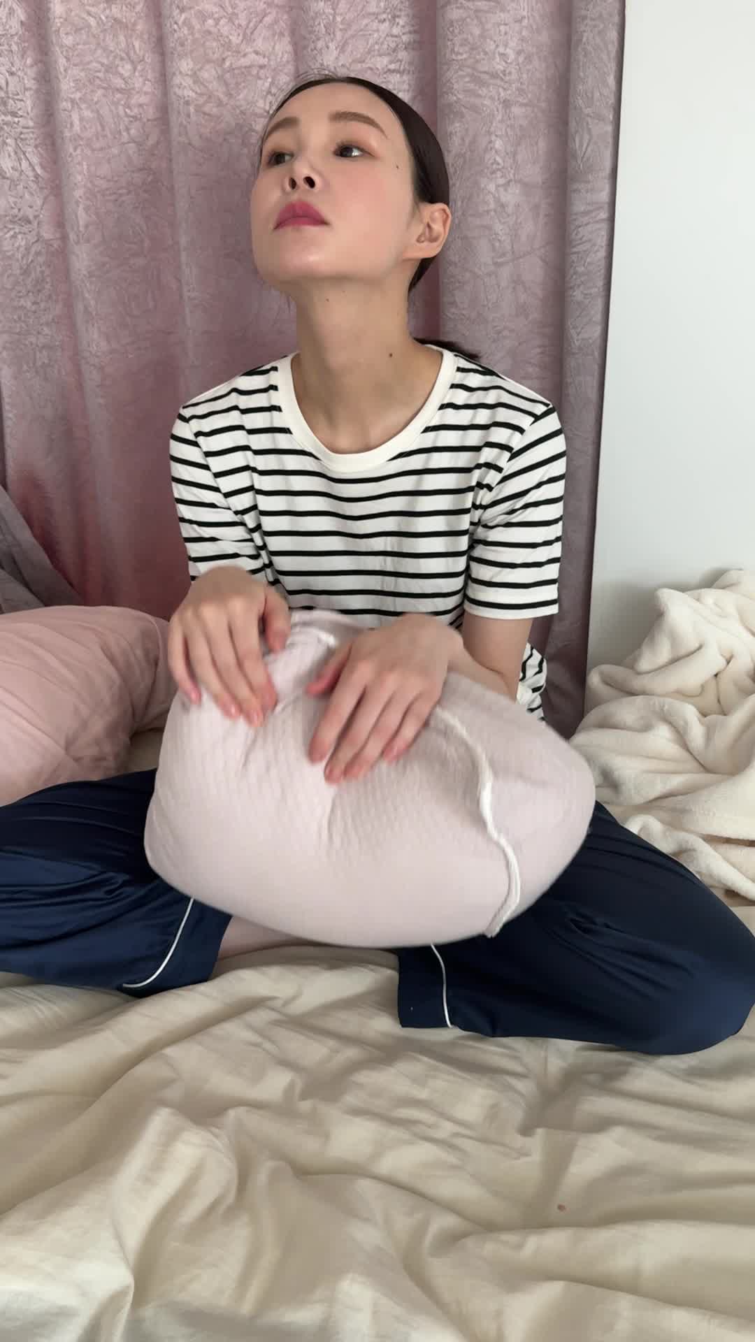 ベッドでクッションを抱え、「このドリンクを続けたら変化があるかな？」と未来を想像する表情