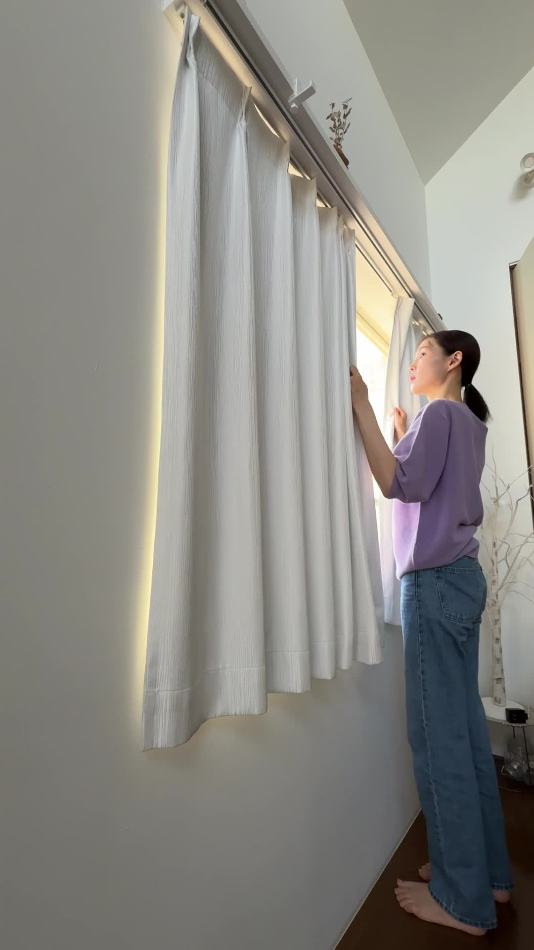 窓際に立って、カーテンを動かす仕草