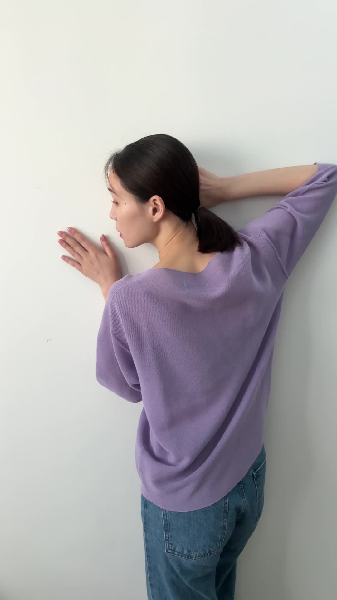 壁に耳を当てて何かを聞いているような仕草