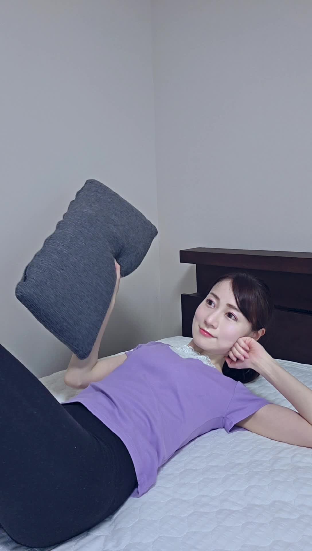 ベッドで横になりながら、ダンベル代わりに枕を持ち上げる動作