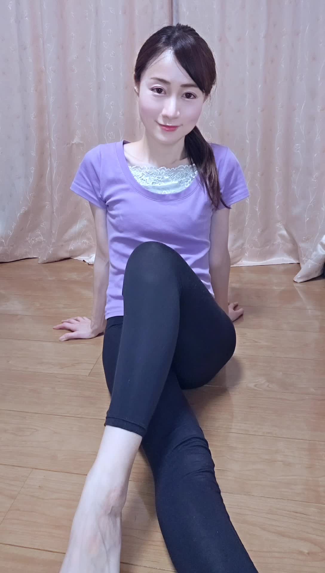 床に座り、足を軽く伸ばしながら「これって意外と気持ちいい！」と微笑む動作