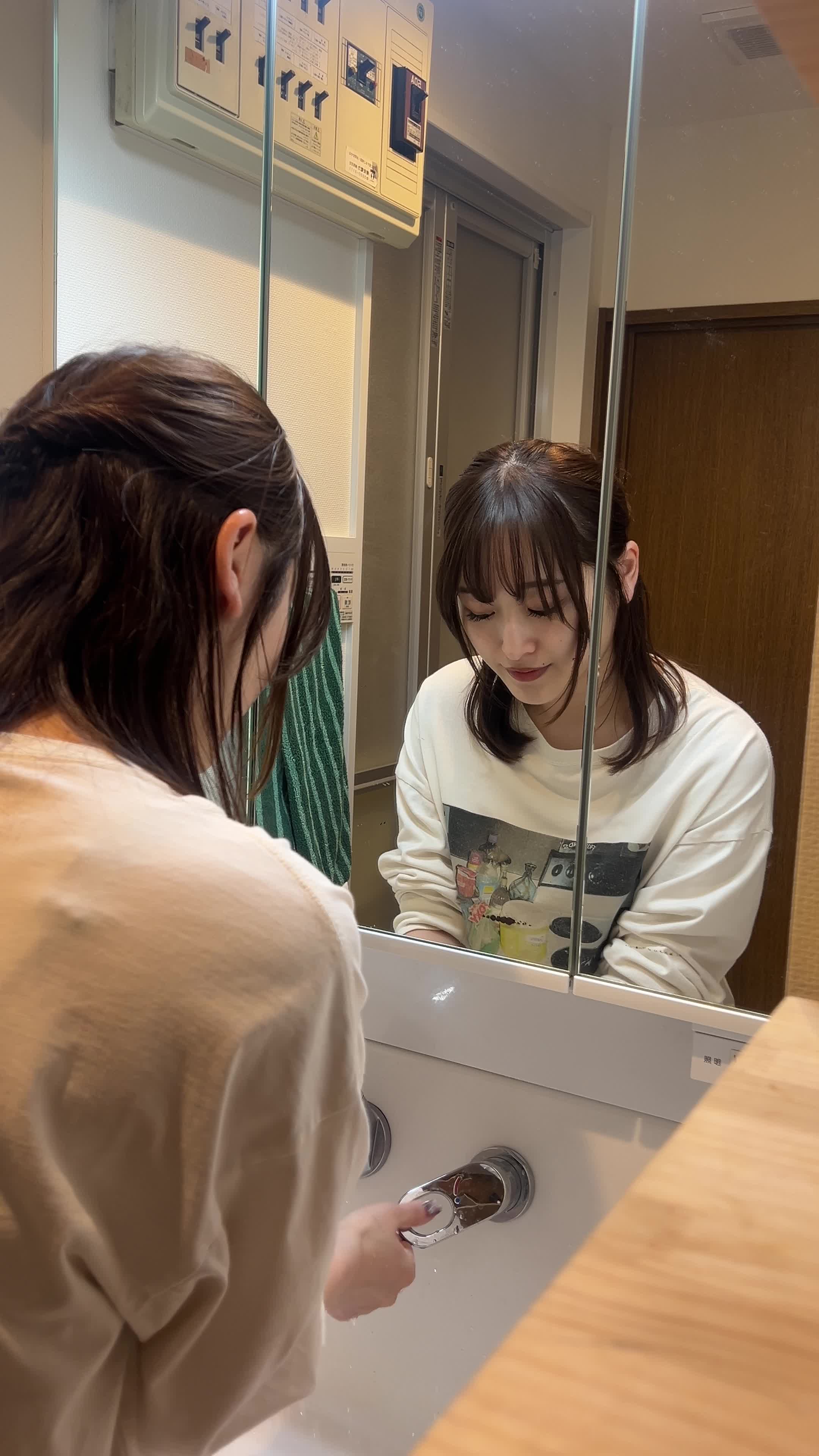 洗面台で手を洗い、顔を軽く拭いている様子を見せる