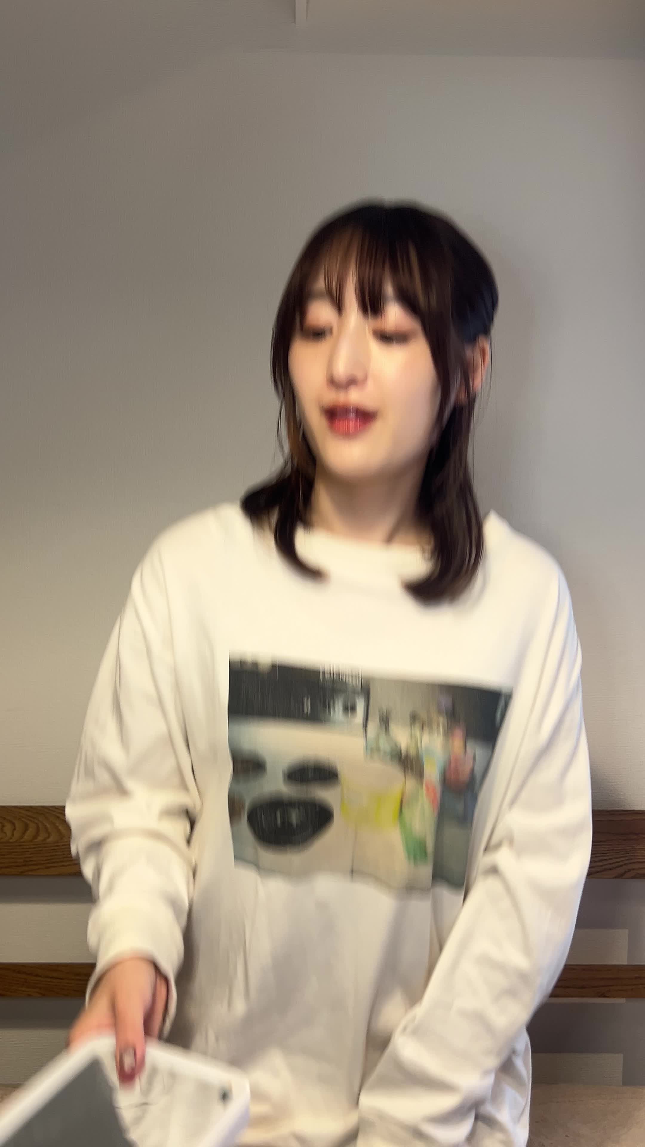 椅子から立ち上がり、鏡を見ながら手で顔を軽く撫でる動作をする