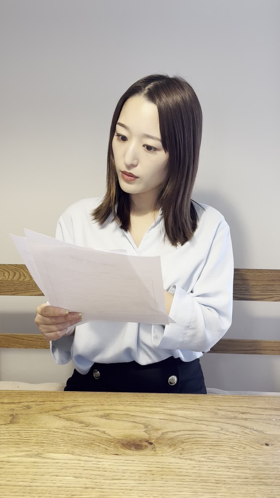 テーブルでカタログを広げ、「これを売ったら次はこの車かな」と考える仕草