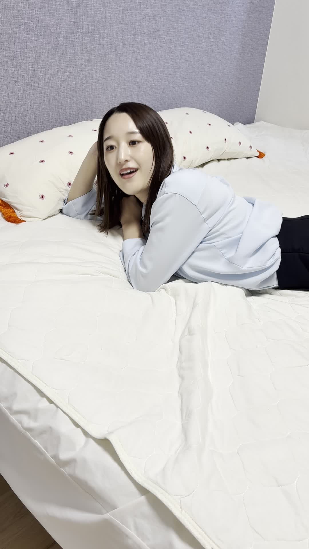 ベッドで横になりながら、「査定額次第で新しい車が買える！」と微笑む表情