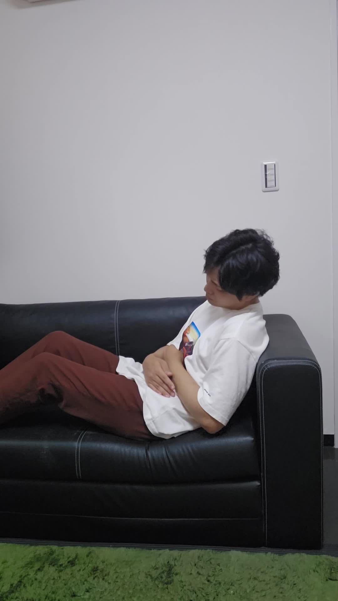 ベッドで横になり、「また便秘が続いている…」と眉をひそめて悩む表情