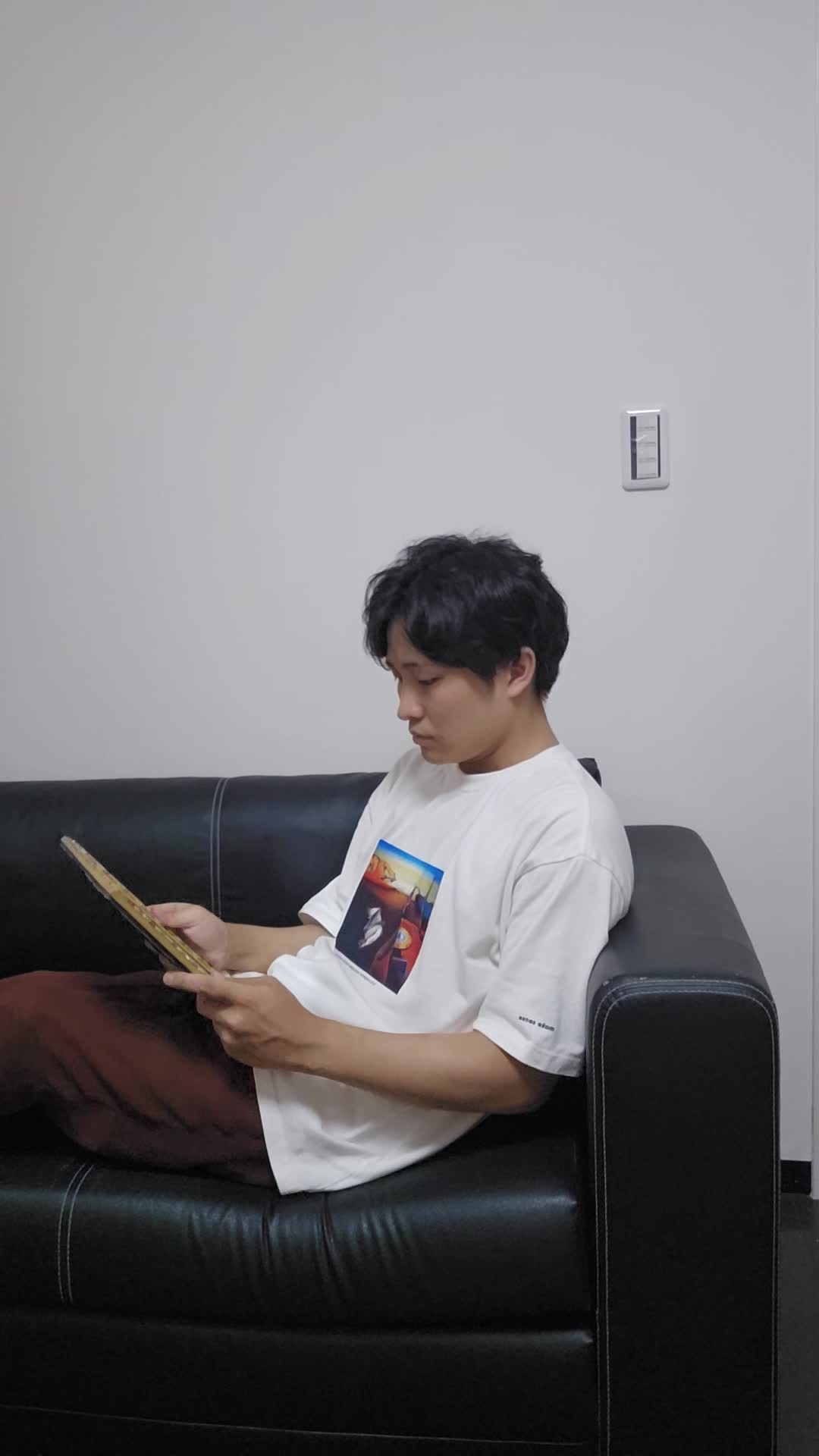 ベッドで脚を伸ばし、「便秘が原因で肌荒れしている気がする…」と鏡を見つめる動作