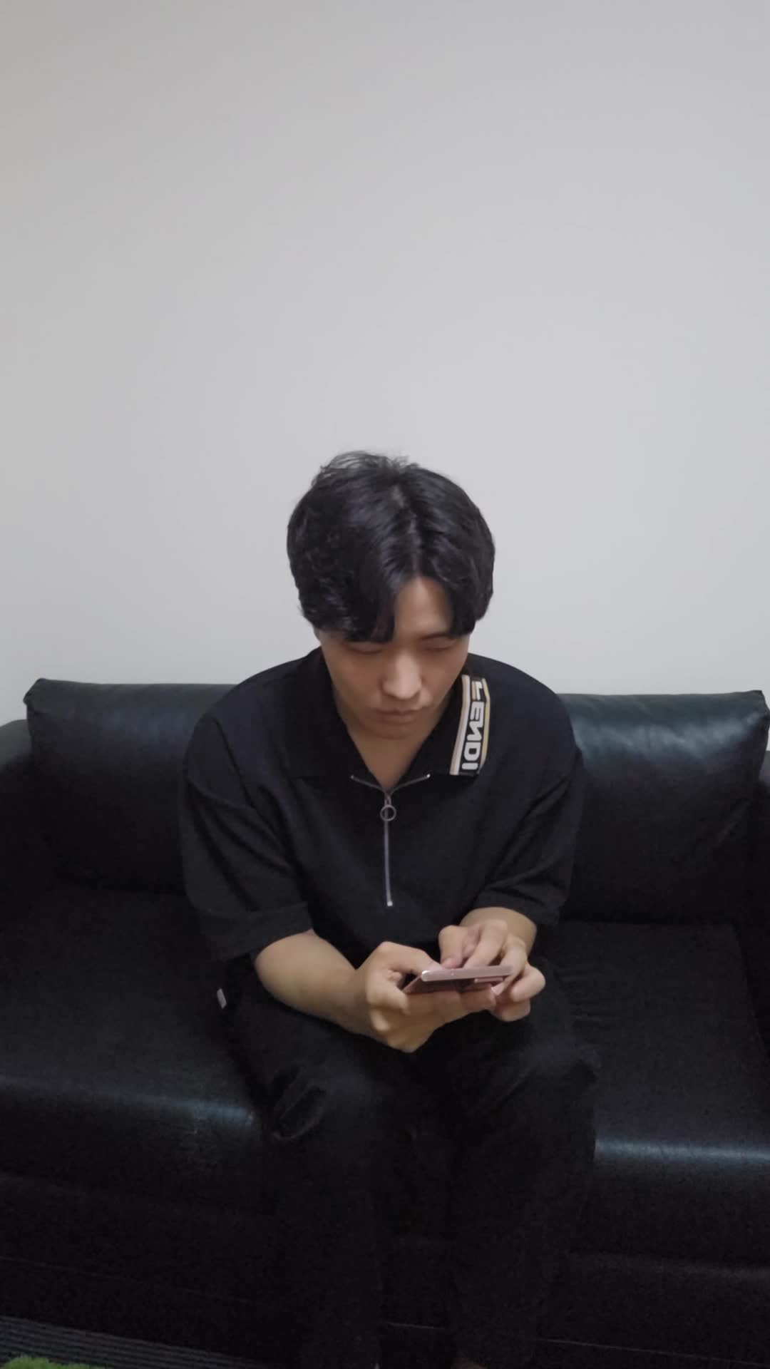 ソファで膝を曲げながら、「疲れた体に何が必要か考えて健康ドリンクを検討する」様子