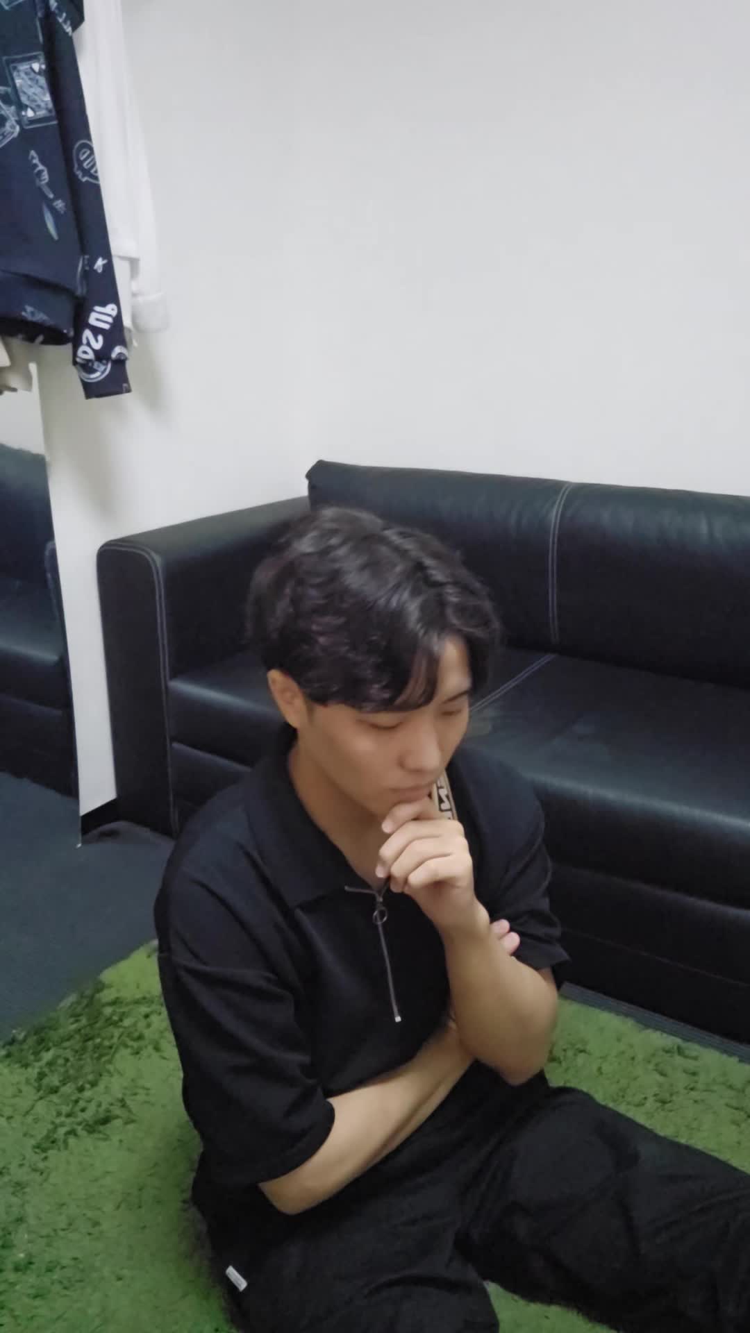 床に膝を崩して座り、「体が重いのは食生活が原因かもしれない」と考え込む姿