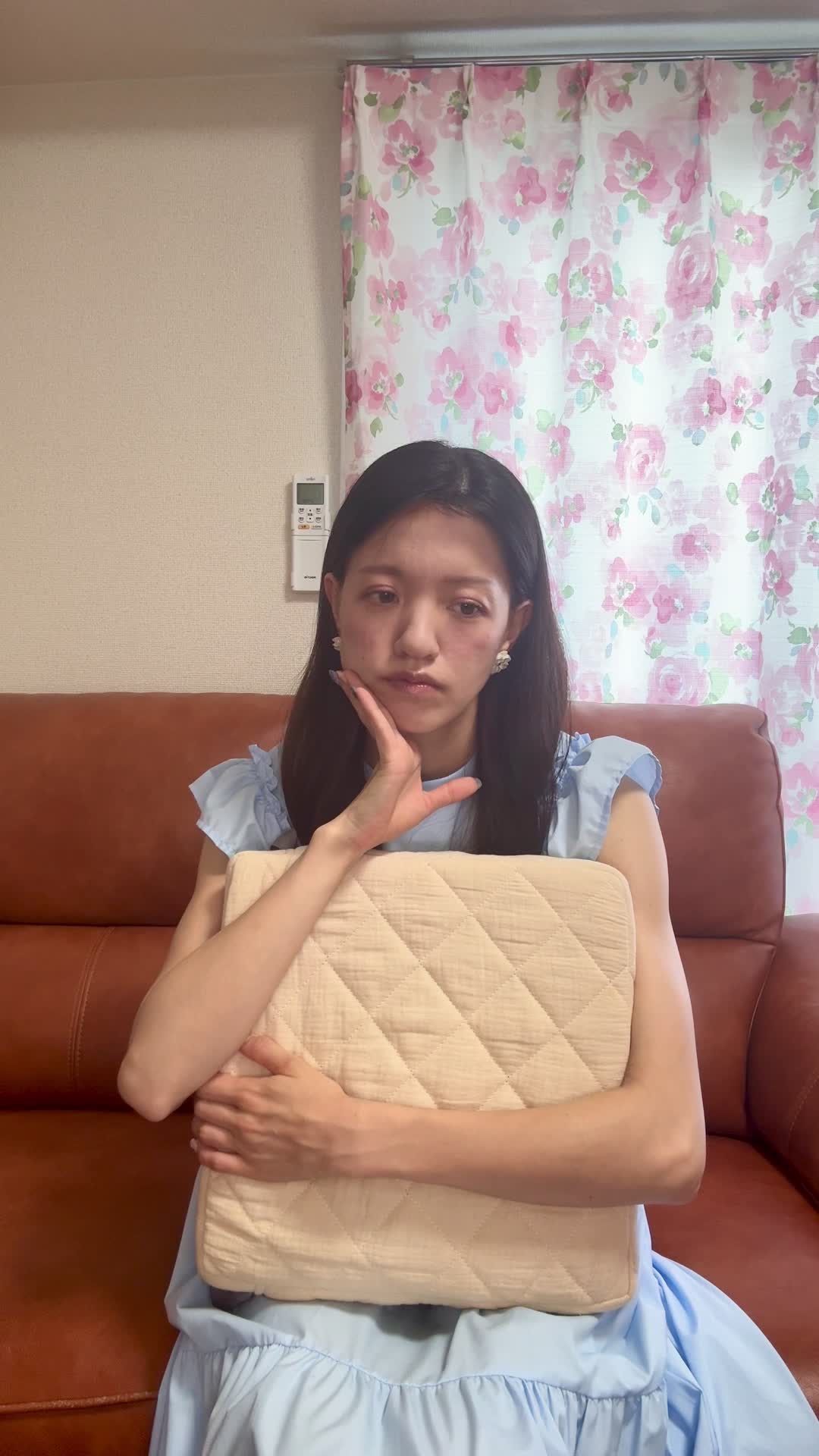 ソファでクッションを抱え、「疲労感が抜けない原因を調べている」集中した表情