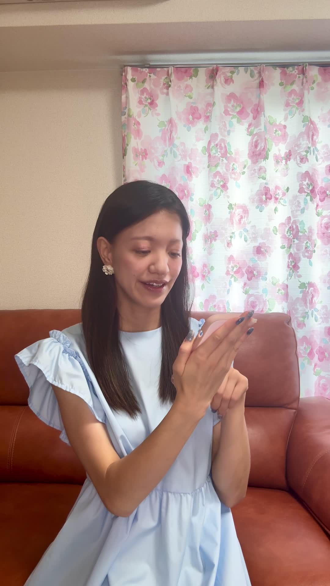 ソファでスマホを眺めながら、「健康ドリンクの口コミを見て少し希望を感じる」表情