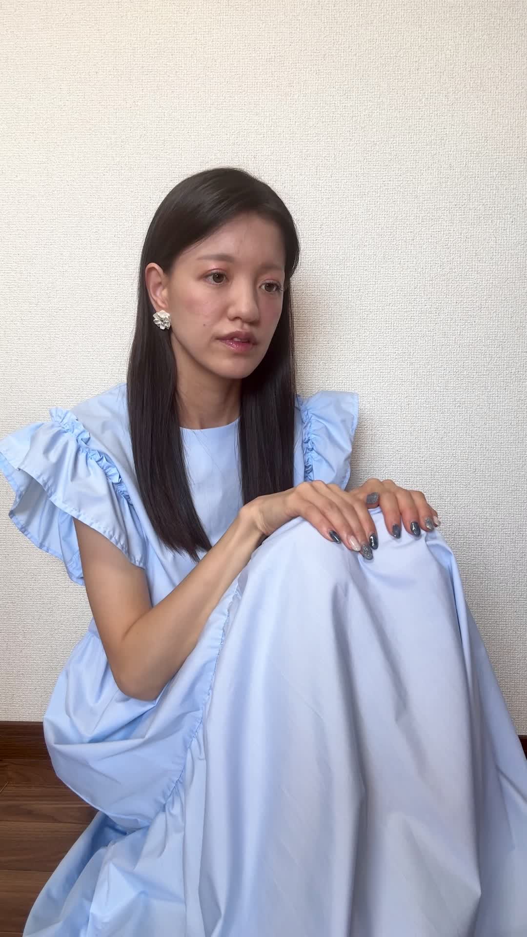 床に座り込み、「最近体が重くて動きが鈍い」と両手を膝に置いて考え込む姿