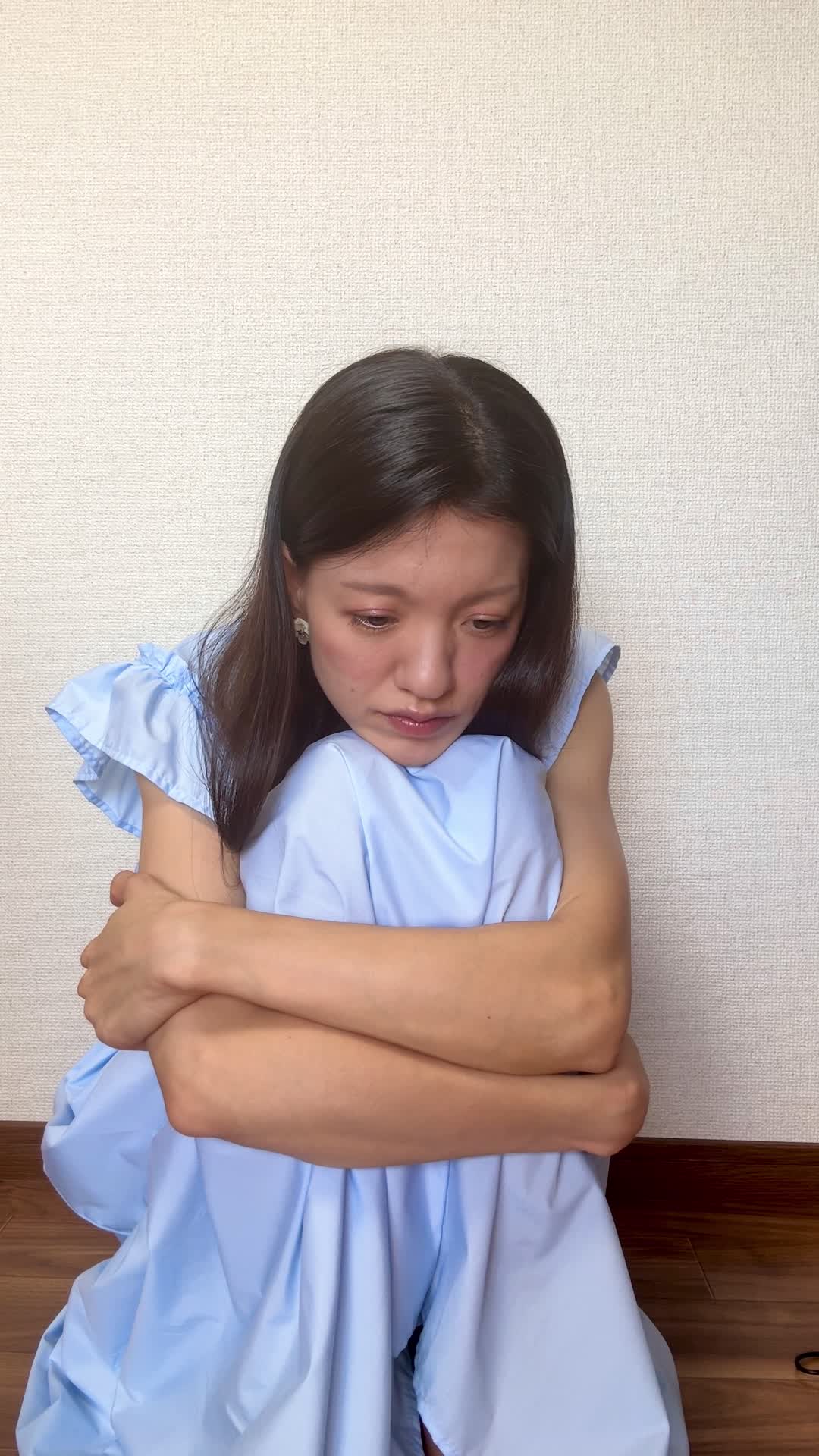 床で膝を抱えながら、「日中のエネルギー不足をどうにかしたい」と考え込む姿