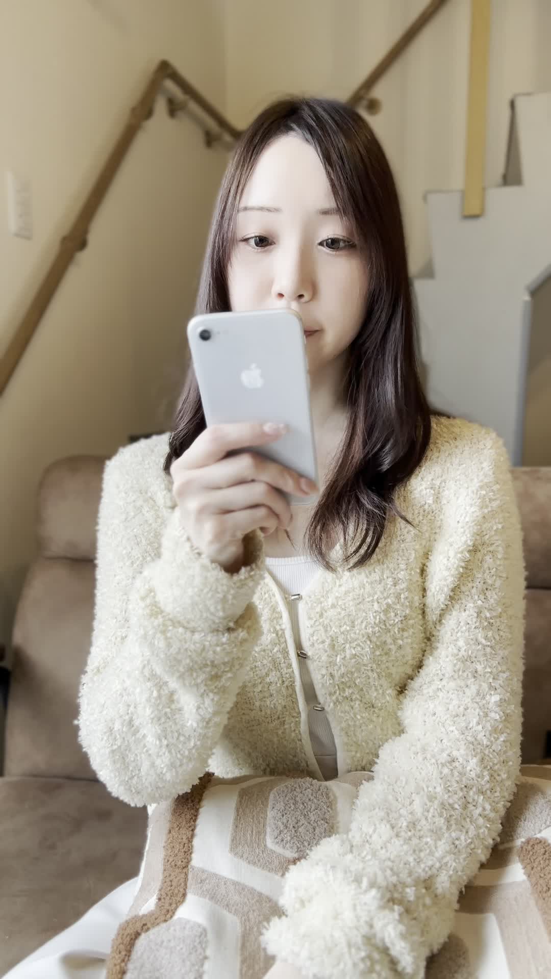 ソファでスマホを置き、「矯正を始める決意を固める」前向きな表情