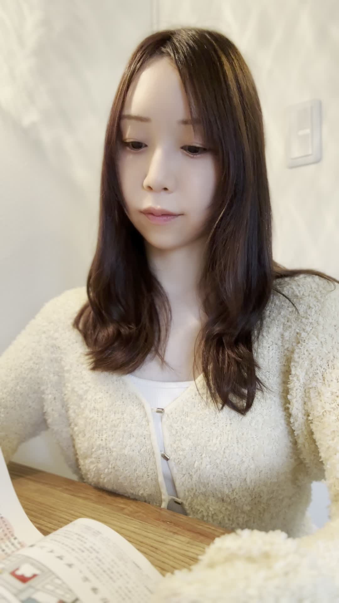 テーブルで矯正治療のカタログを見ながら、「これなら目立たないかも」と安心する表情