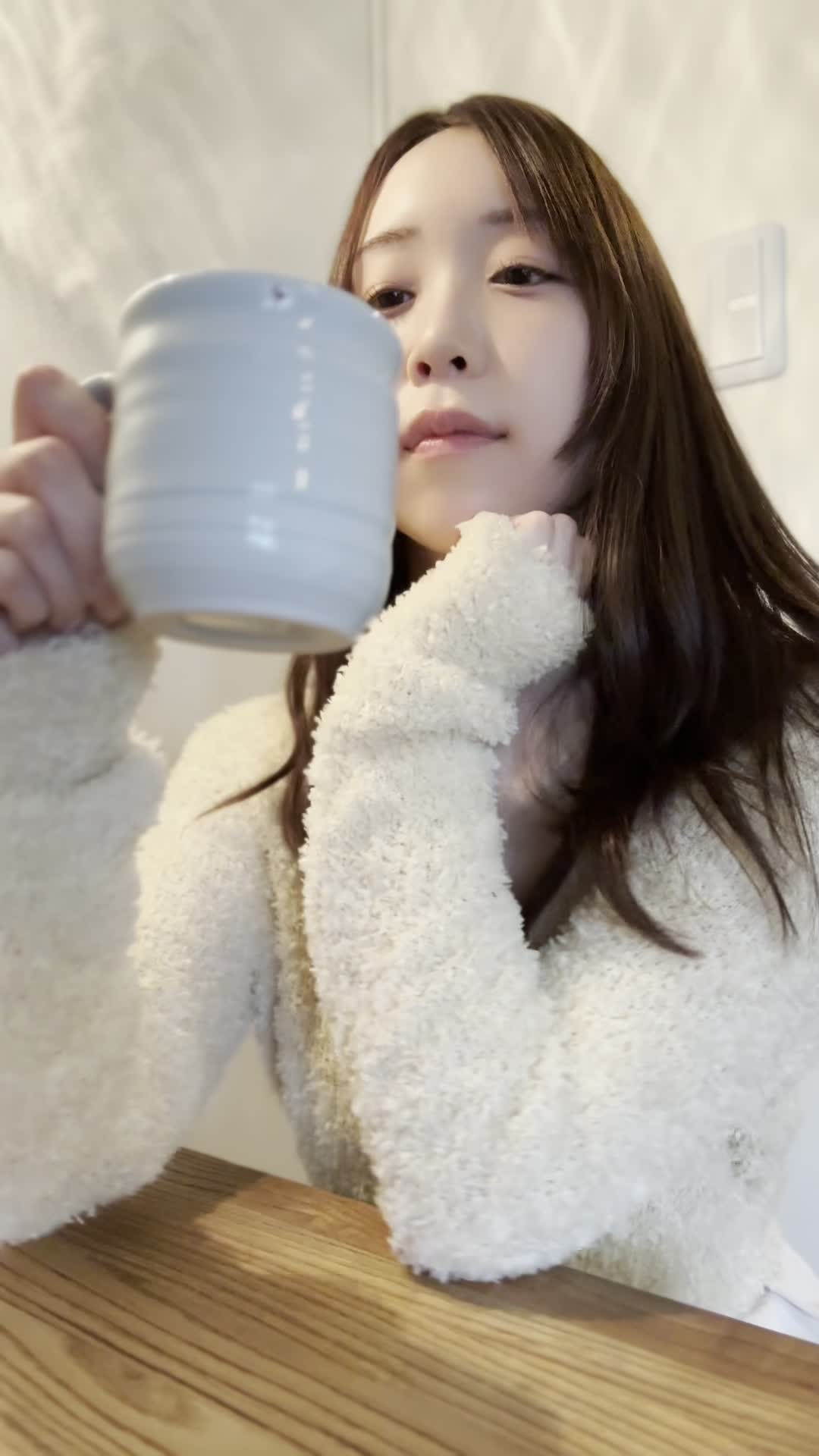 テーブルでカップを手に取り、「矯正中でも食べやすいメニュー」を考える表情