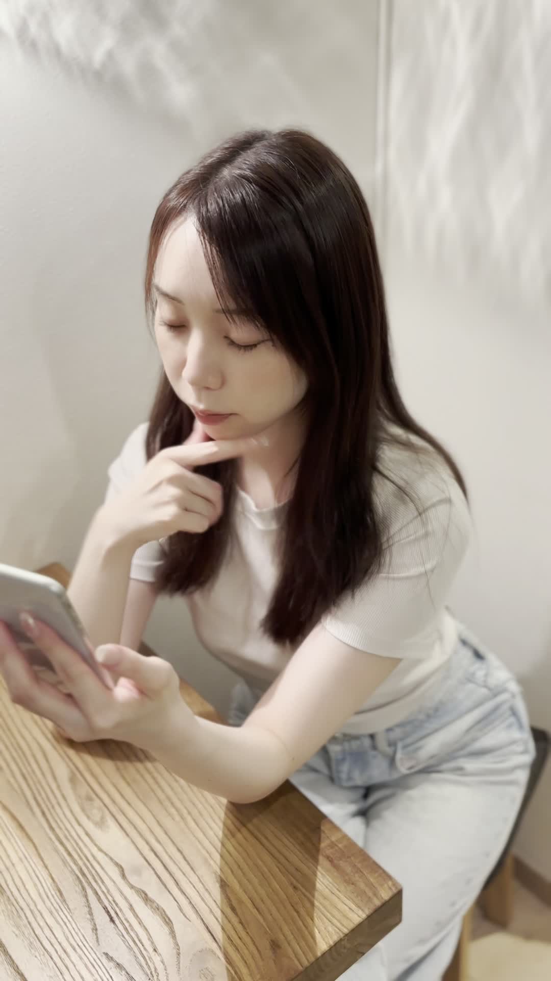 椅子に浅く腰掛け、「クーポンを適用してさらにお得に」とスマホを操作する姿