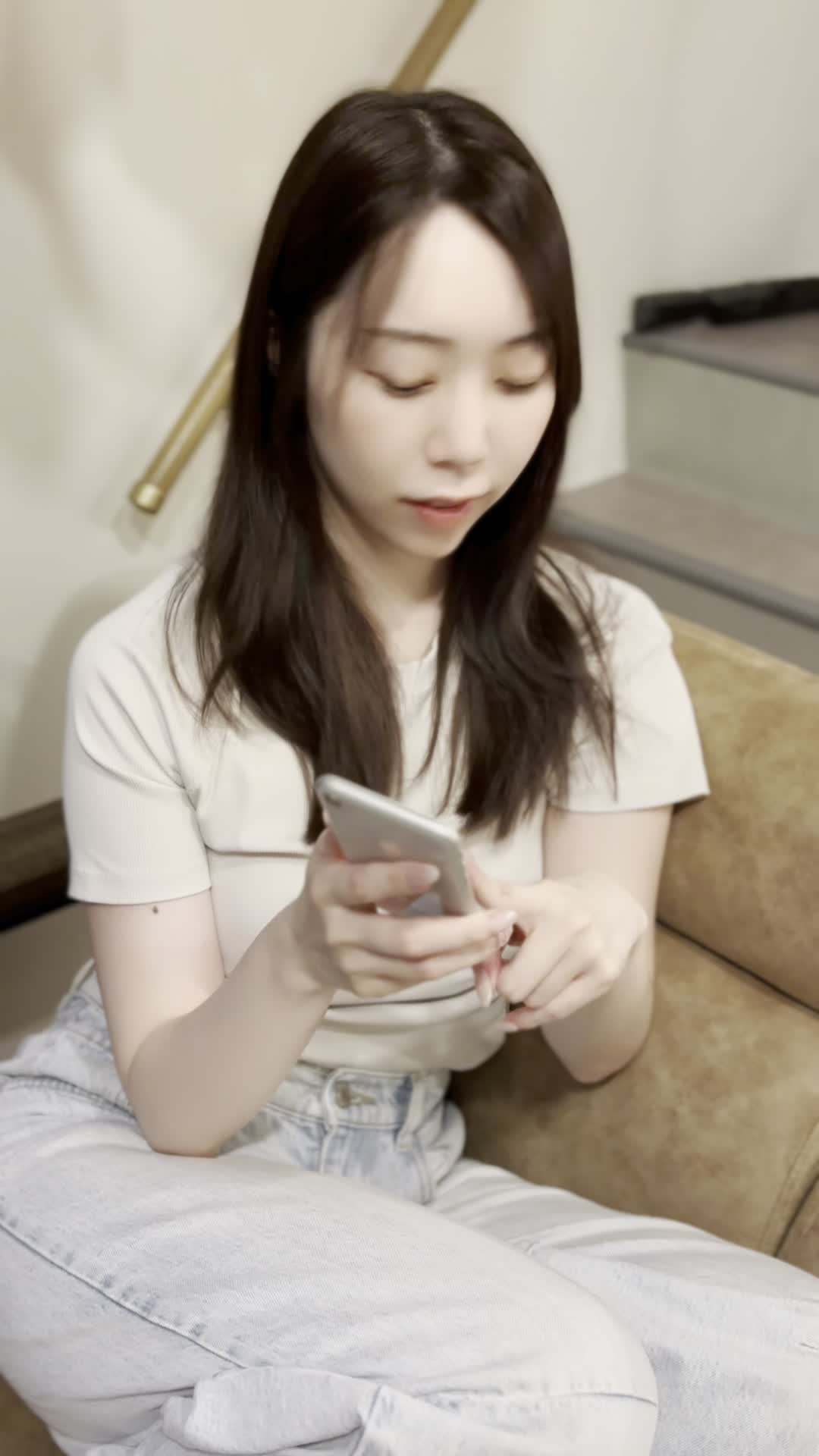 ソファで友達と話しながら、「これが新作だよね！」と嬉しそうに見せる姿