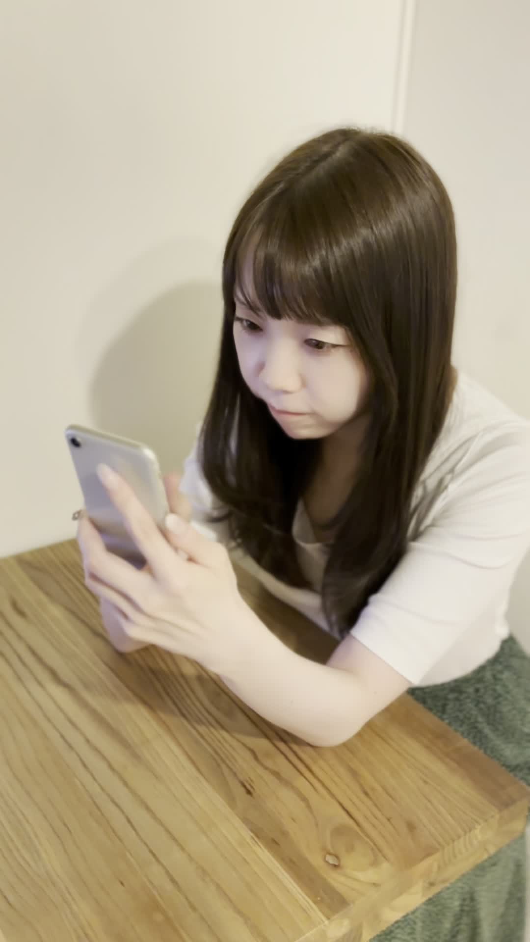 テーブルでスマホを操作しながら、「体臭ケアのおすすめ商品を調べる」集中した様子