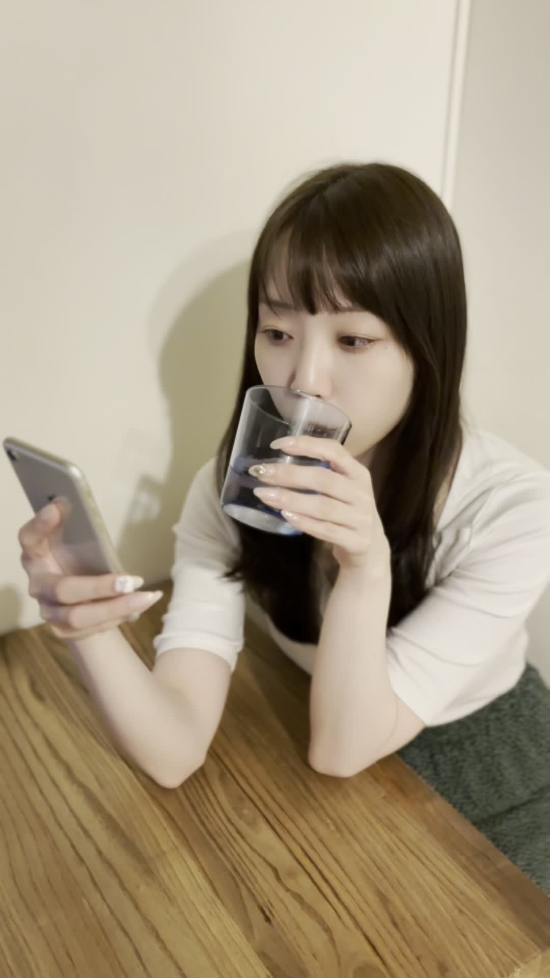 テーブルで水を飲みながら、「次の体臭ケアアイテムを選ぶ」リラックスした表情