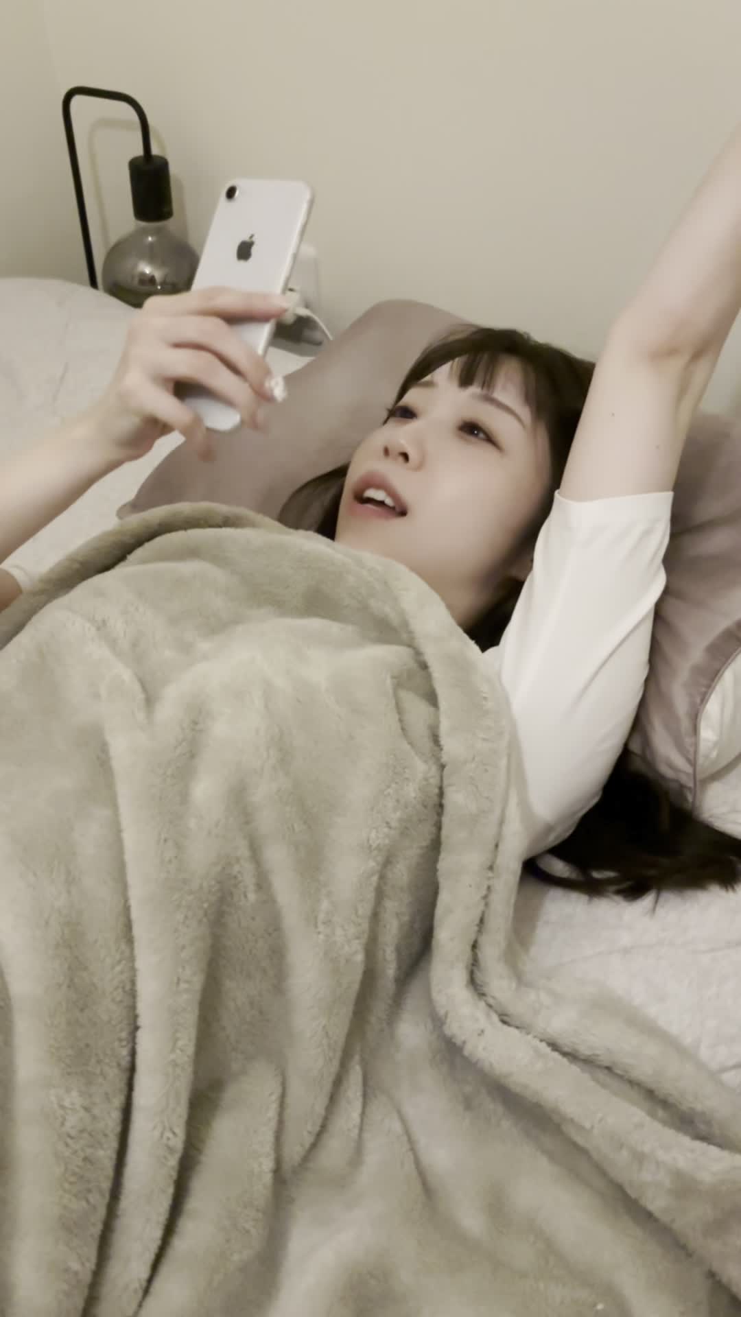 ベッドで脚を伸ばし、「体臭ケアでどれくらい効果が出るか調べる」期待の表情