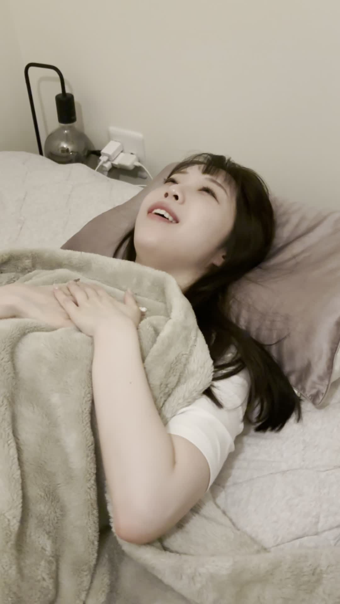 ベッドで横になりながら、「新しい自分に期待して胸を膨らませる」リラックスした笑顔