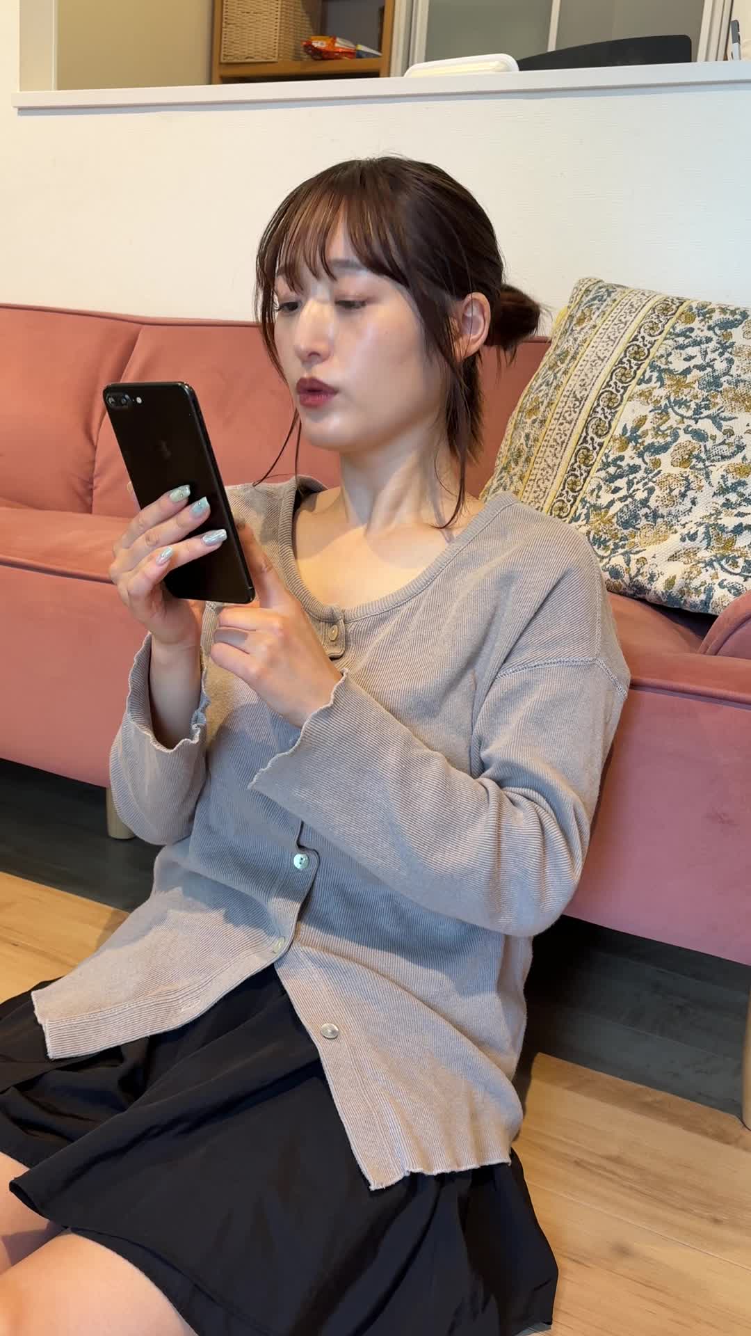 床に座り込み、スマホのカレンダーを見る様子