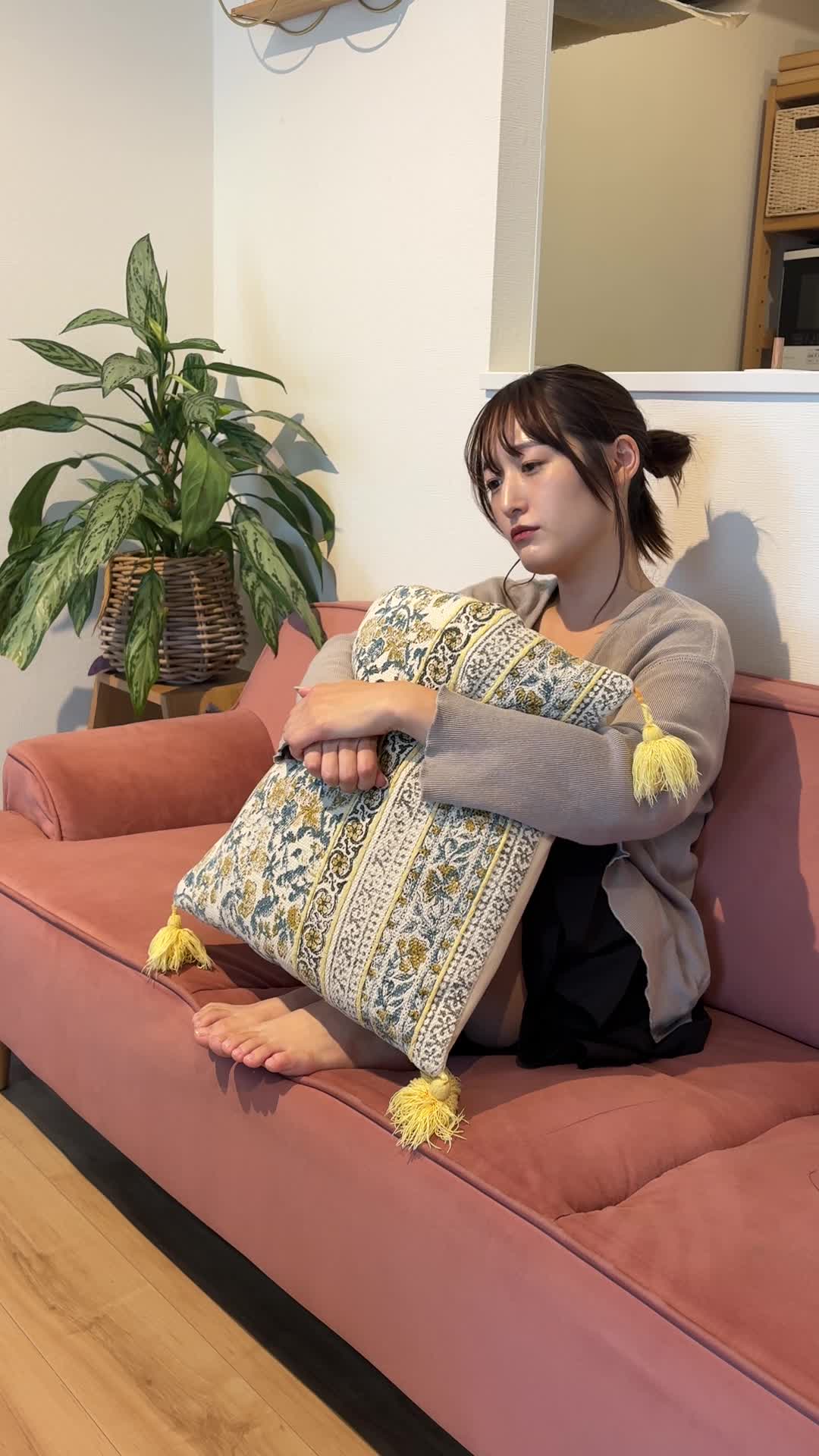 ソファで膝を抱え、「どうしてもっと早く気づかなかったんだろう」と悩む姿