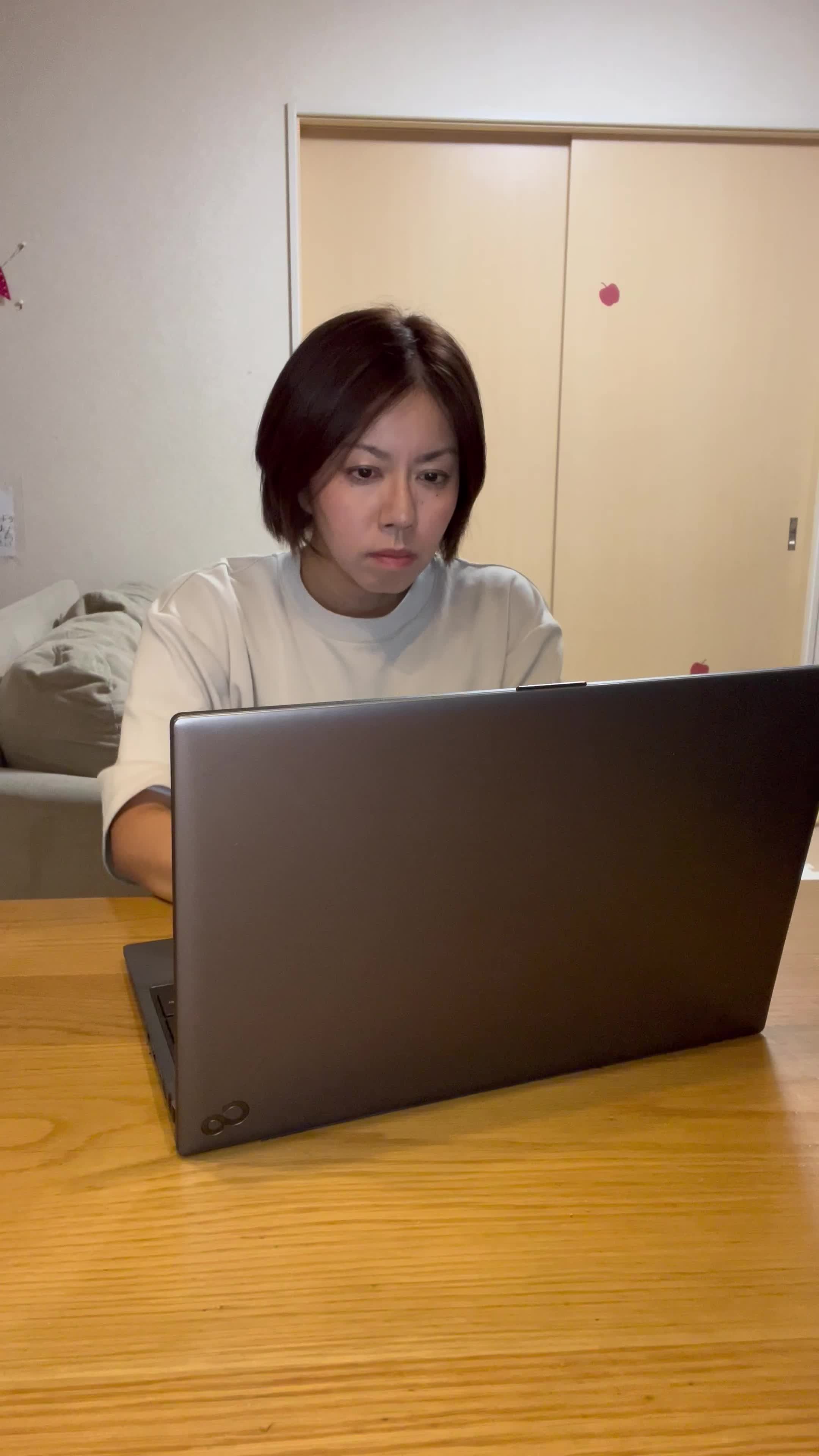 椅子に座り、仕事中に髪のパサつきが気になり、少しイライラする表情を見せる姿