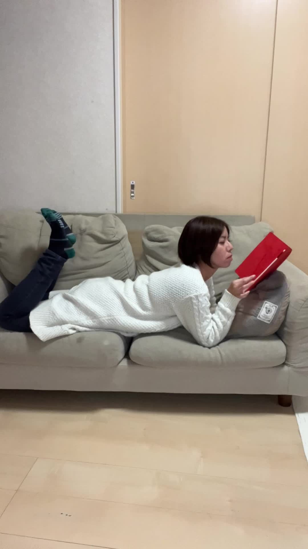 ソファに横座りして、手帳に目を通しながら次を考える表情